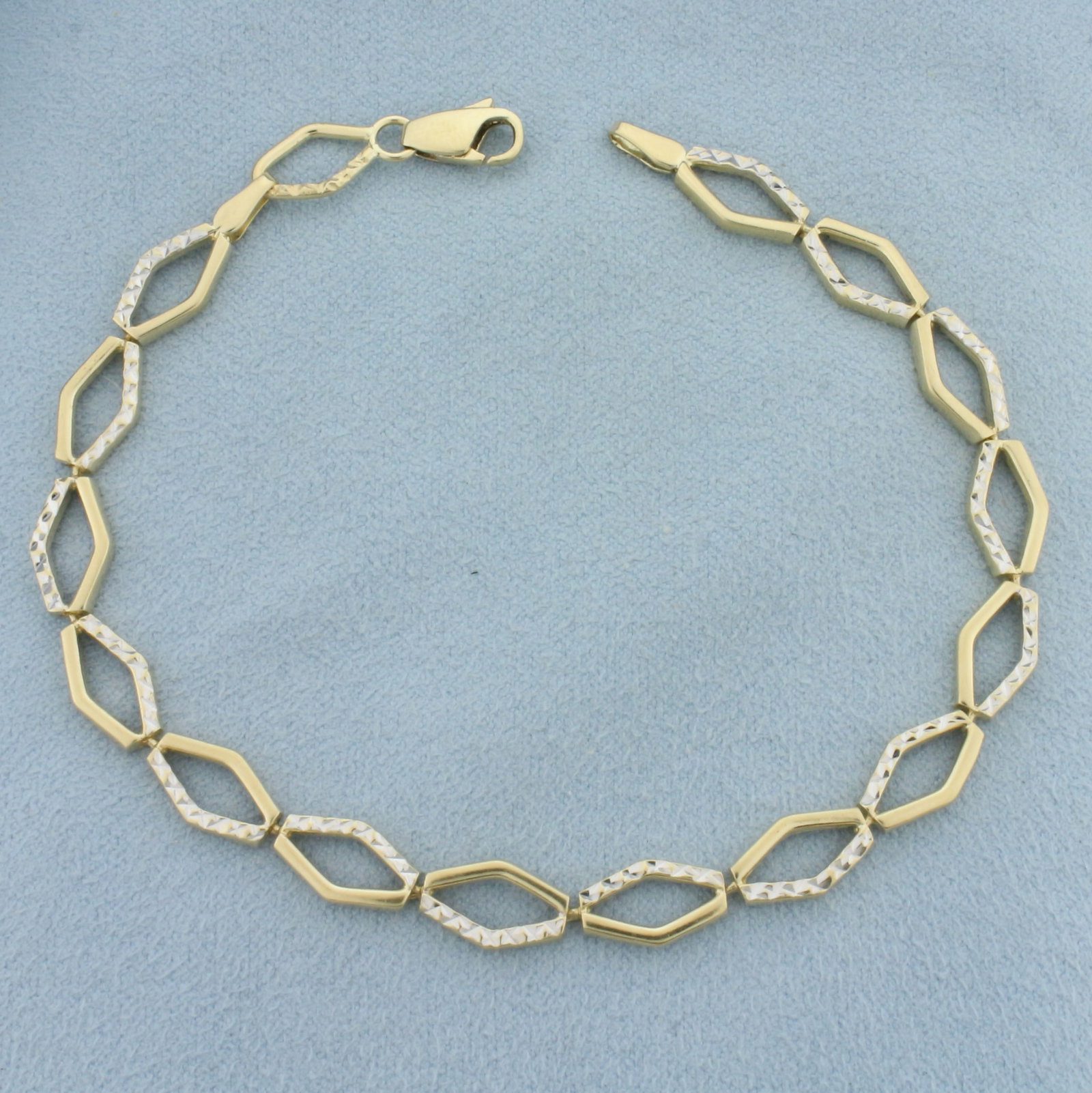 Two Tone Designer Diamond Link Bracelet in 14k Yellow and White Gold: In 14k yellow and white gold. Diamond cut detail on white gold to mimic sparkle of diamonds. 8 1/8 inches long, 6.4mm wide. Lobster clasp. 7.3g.