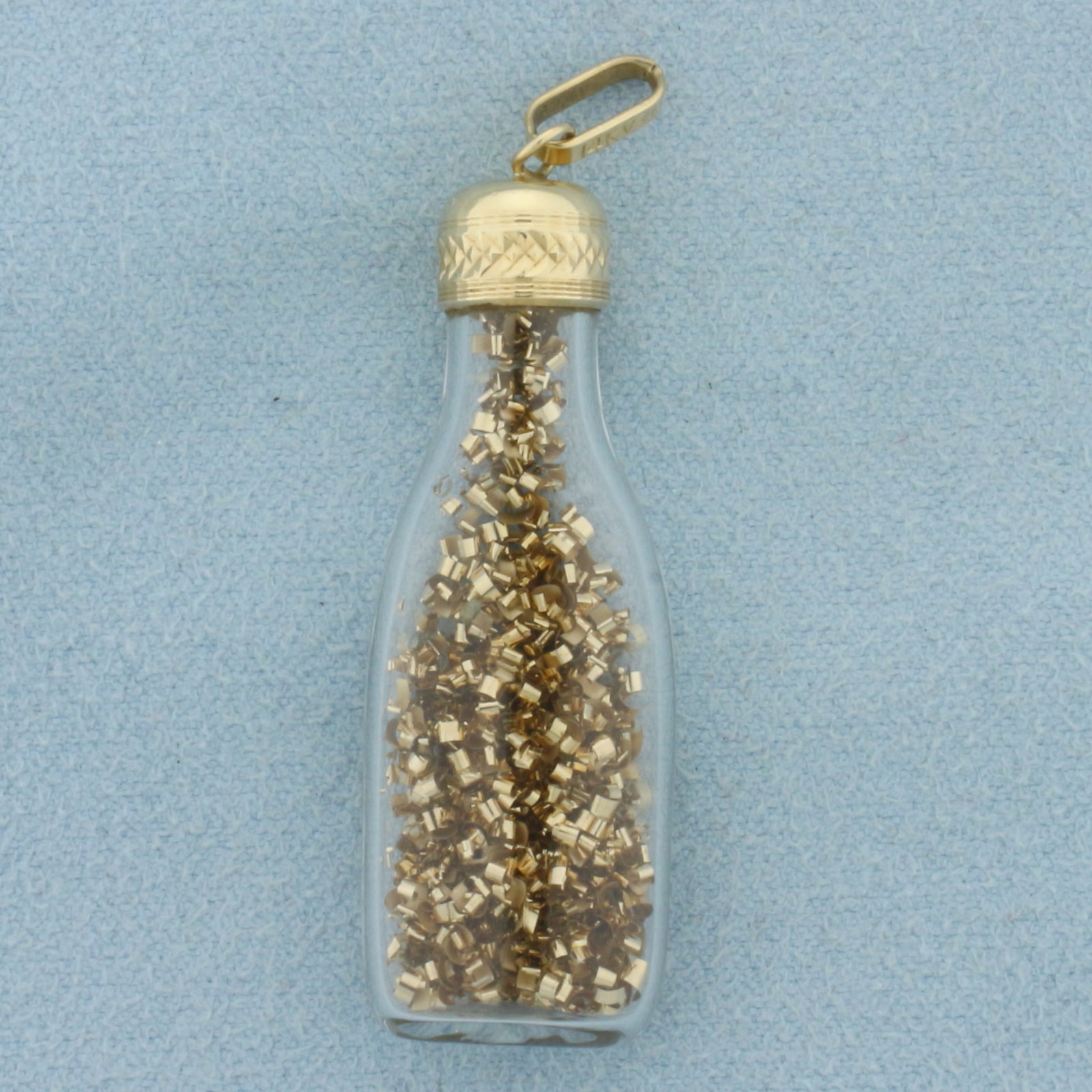 Gold Flakes in Bottle Pendant in 14k Yellow Gold: In 14k Yellow Gold. 1 7/8 inch long including bale. 1/2 inch wide. 3.7g.