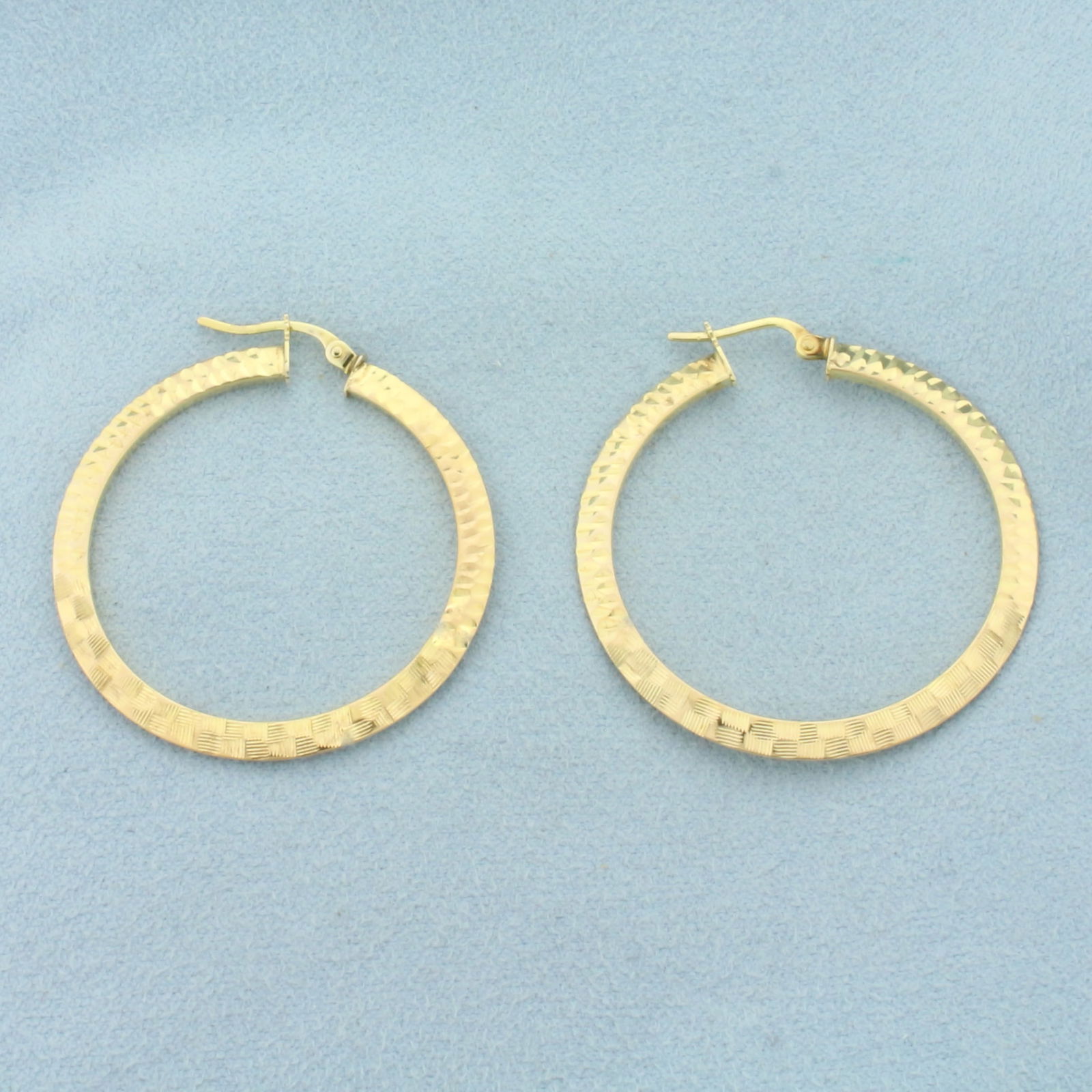 Textured Etched Large Hoop Earrings in 10k Yellow Gold: In 10k Yellow Gold. 1 3/8 inch diameter. Diamond cut textured design for unique look. Leverback. 2.7g.