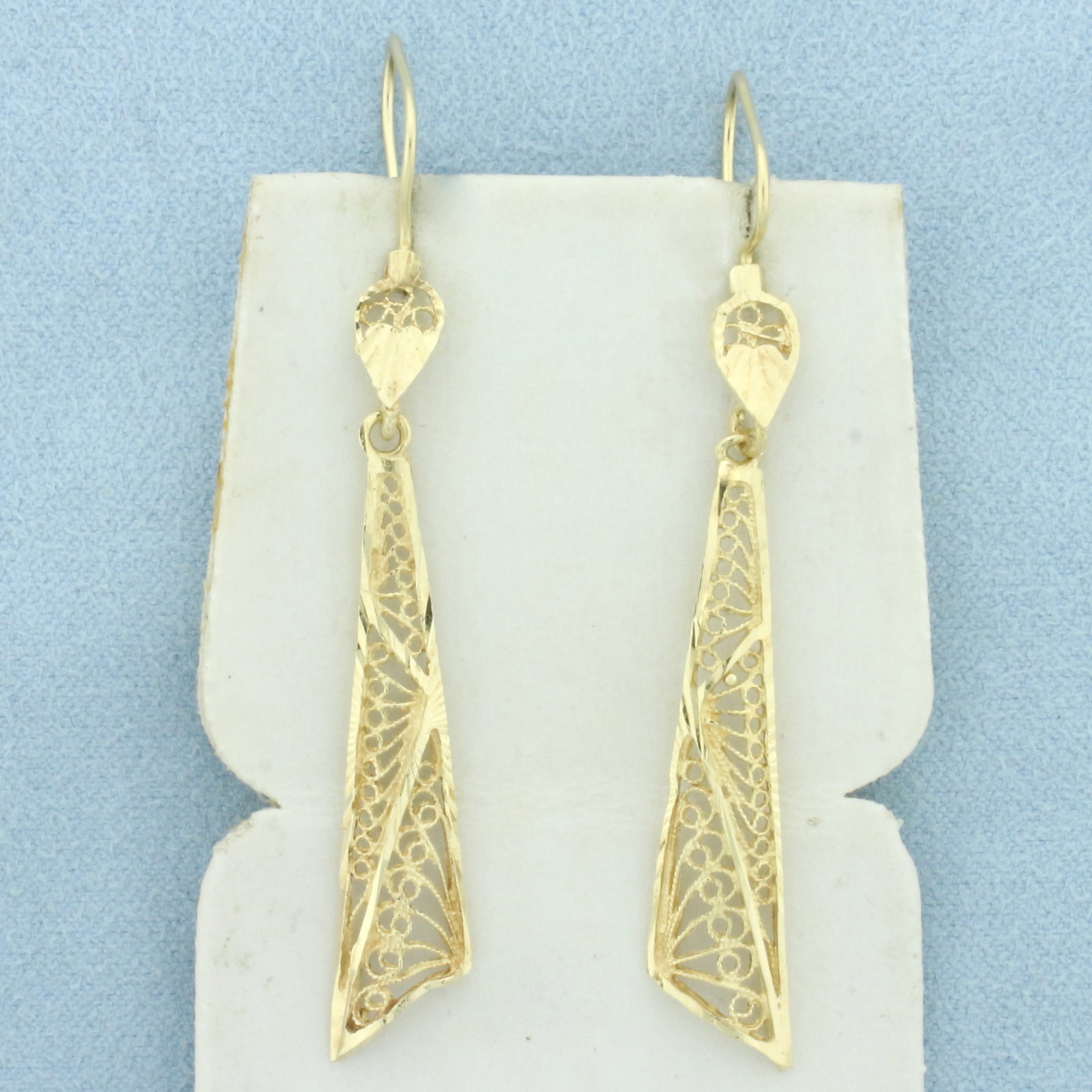 Cut Out Filigree Dangle Earrings in 14k Yellow Gold: In 14k Yellow Gold. 2 3/8 inches long. 3/8 inchwide. Locking hook backs. 2.8g.