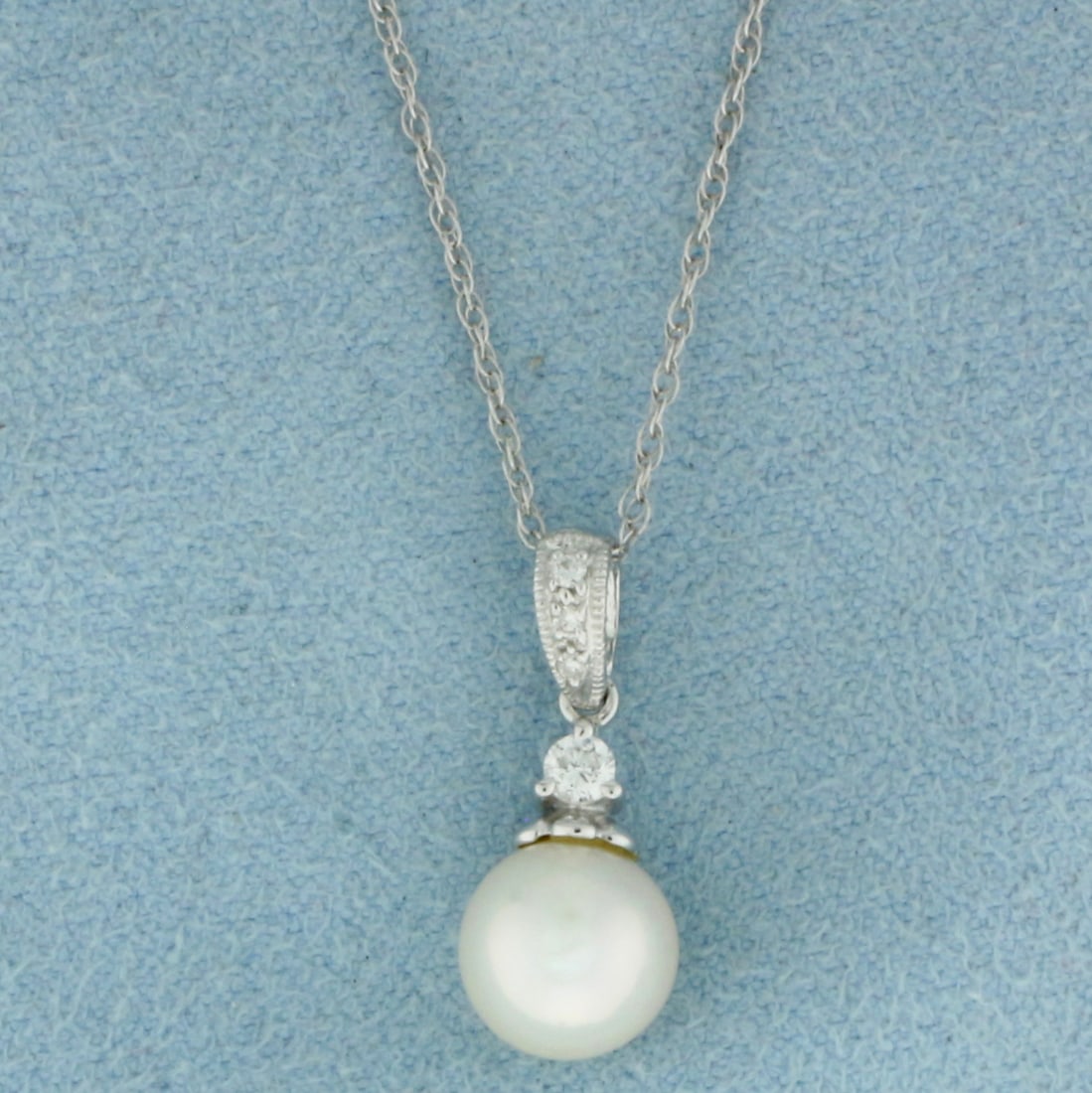 Cultured Akoya Pearl and Diamond Necklace in 14k White Gold: In 14k White Gold. Contains one 7.6mm high quality Cultured Akoya Pearl gemstone with high luster. Also contains one .05ct and three 1/2pt high quality diamonds, SI clarity/G color. Pendant is 3/4 inc