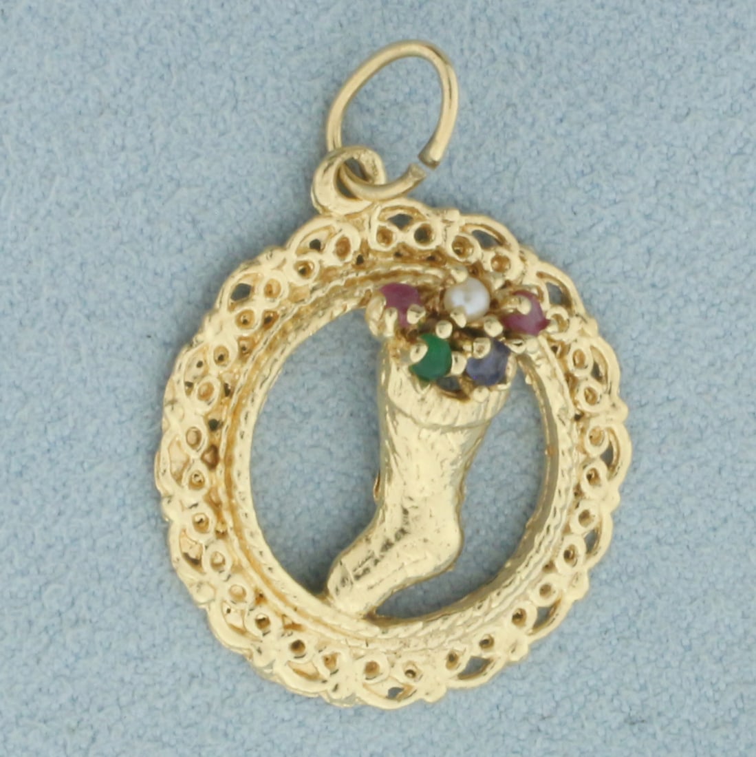 Christmas Stocking Charm or Pendant in 14k Yellow Gold: In 14k Yellow Gold. Contains 1.5mm high quality gemstones: Ruby, Seed Pearl, Emerald, and Sapphire. 1 1/8 inch long including jump ring. 7/8 inch wide. 3.2g.