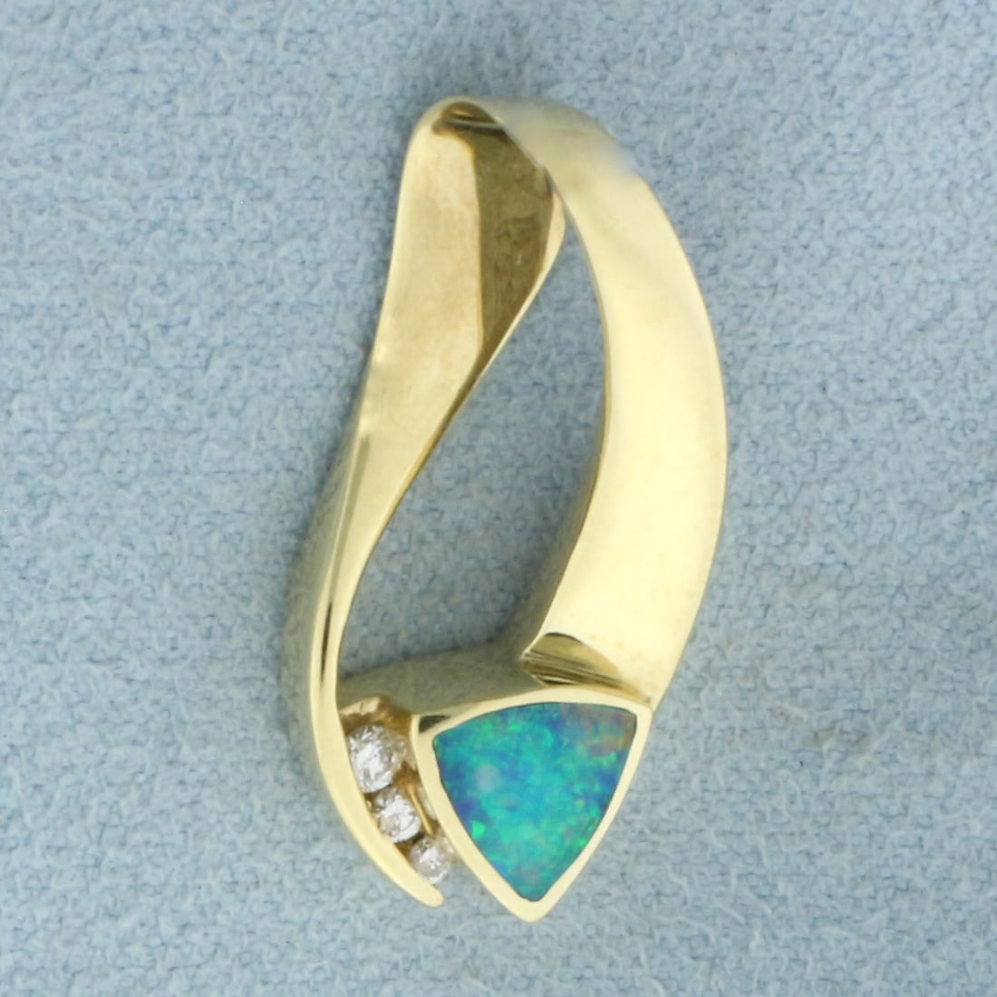 Black Opal and Diamond Slide Pendant in 14k Yellow Gold: In 14k Yellow Gold. Contains three high quality .02ct diamonds, SI clarity/G color. Also contains one natural 7mm trillion Opal gemstone with intense play of color and flashes of green and red. 1 inch