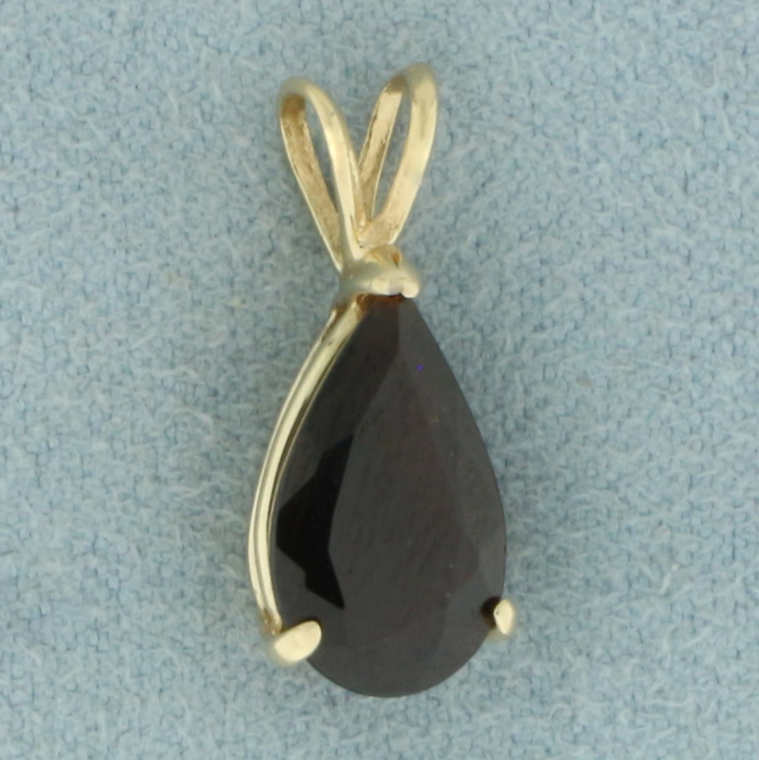 Garnet Solitaire Pendant in 14k Yellow Gold: In 14k Yellow Gold. Contains one 7x12mm high quality pear cut natural Garnet gemstone, approximately 2cts, with deep color and excellent clarity. 5/8 inch long. 1/4 inch wide. 1.2g.