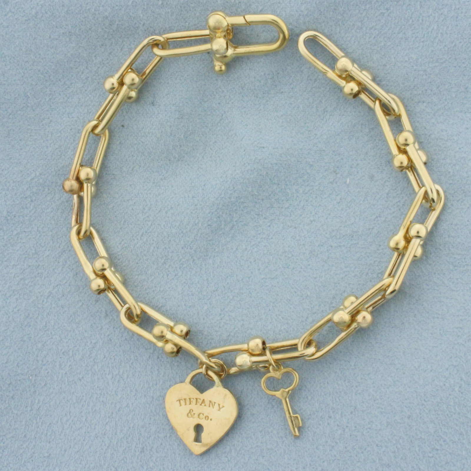 Tiffany and Co. Heart Lock and Key Bracelet in 18k Yellow Gold: In 18k Yellow Gold. 7 1/8 inches long. 1/4 inch wide. 10.0g.