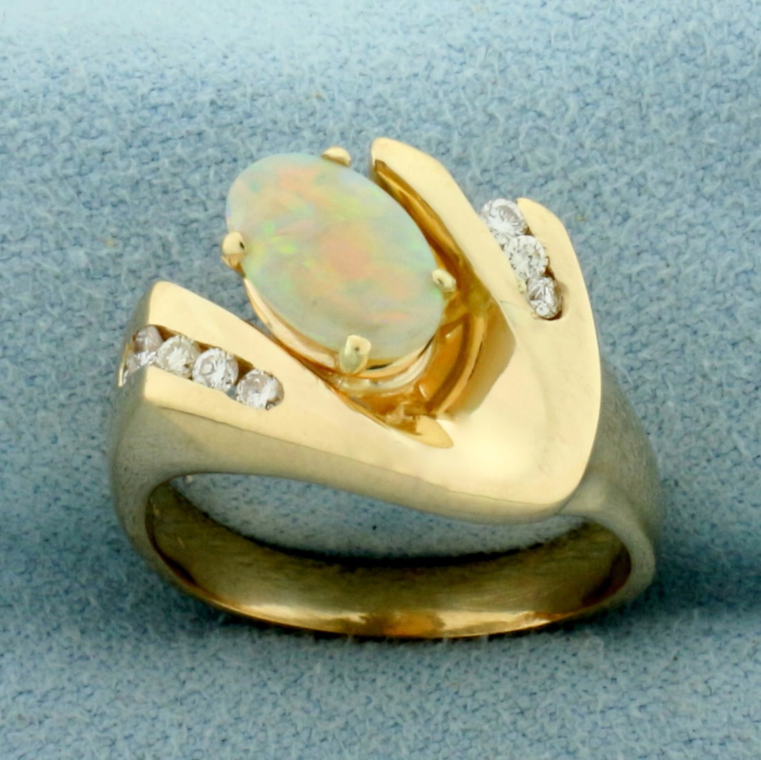 Opal and Diamond Ring in 14k Yellow Gold: In 14k yellow gold. Contains one high quality natural 9x6mm Opal gemstone with excellent play of color and flashes of blue, green, orange, yellow, and red. Also contains eight .01ct diamonds, VS clari