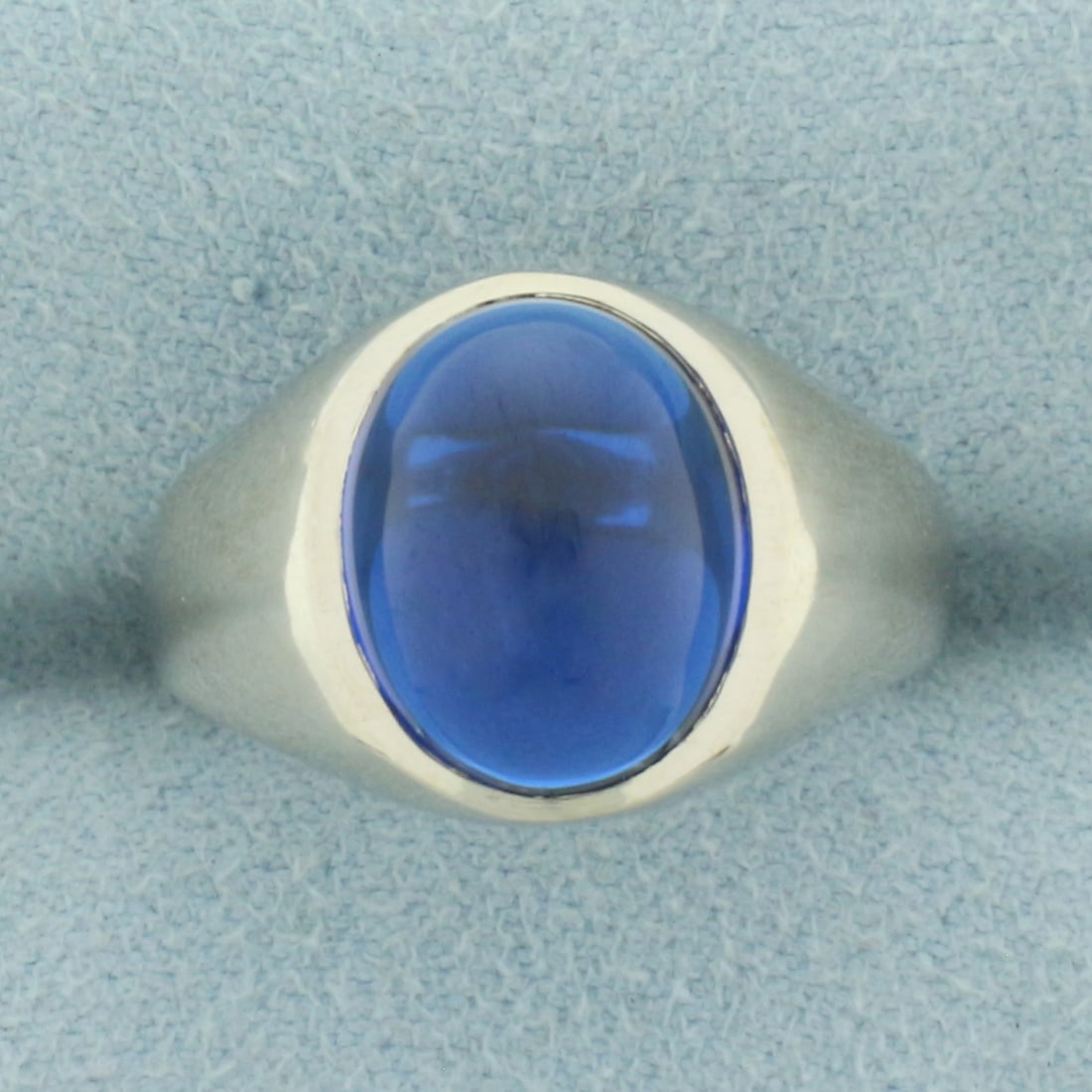 Spinel Solitaire Ring in 10k White Gold: In 10k White Gold. Contains one 10x12mm high quality cabochon Spinel gemstone with intense sapphire color and excellent clarity. Size 7. 4.8g.