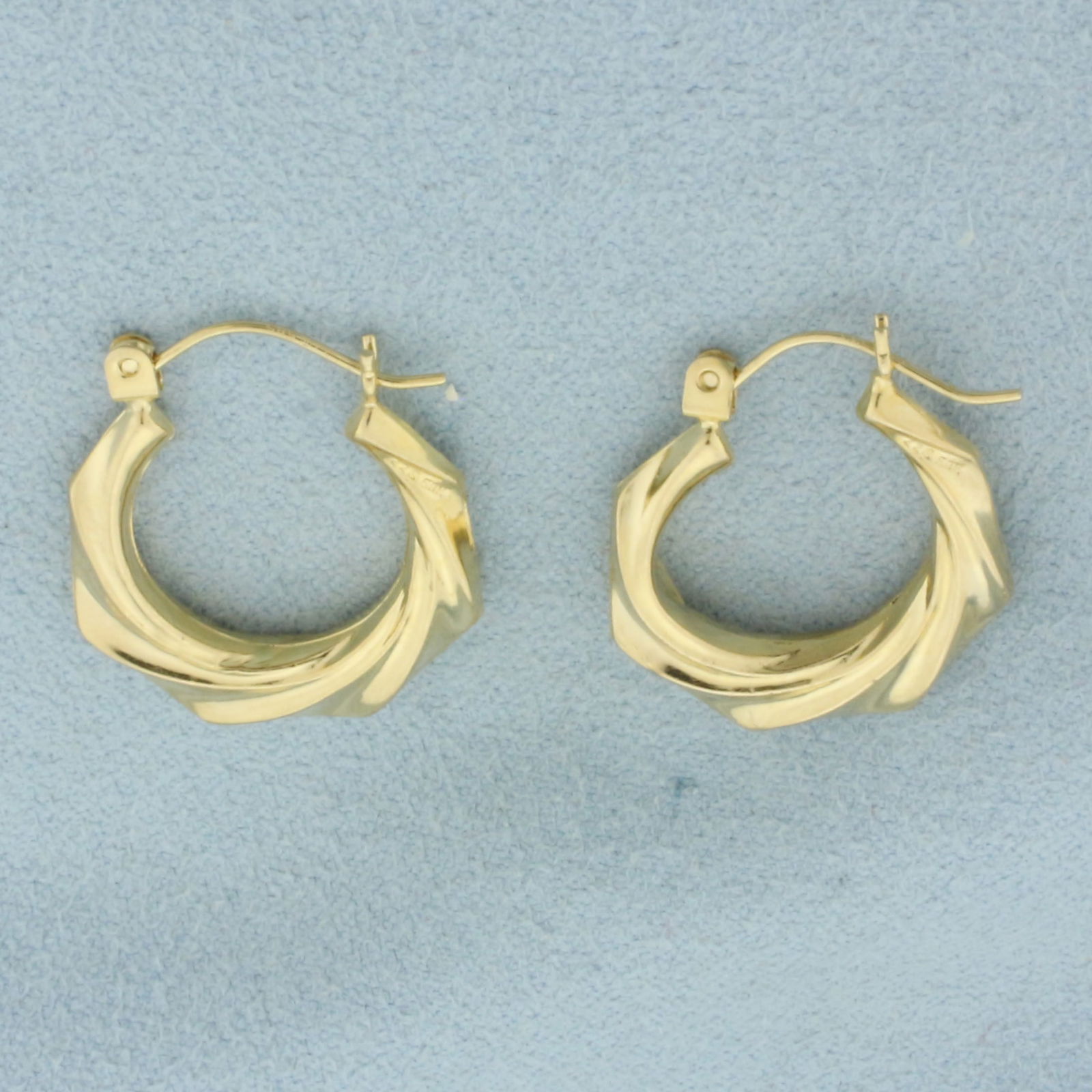 Twisting Design Hoop Earrings in 14k Yellow Gold: In 14k Yellow Gold. 7/8 inch long, 3/4 inch wide. 3.6mm thick. Hinged backs. 1.5g.