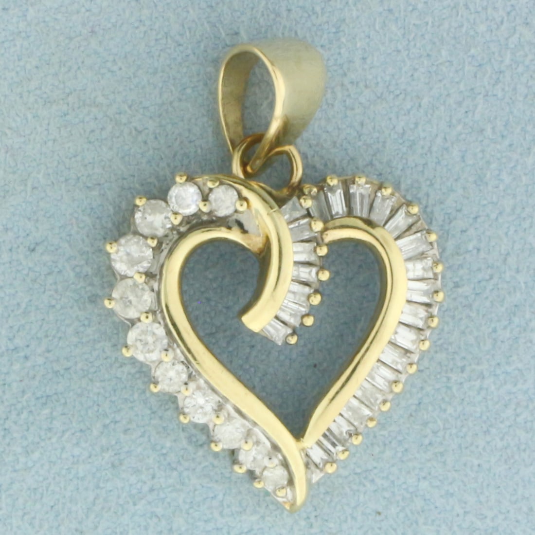 Diamond Heart Pendant in 10k Yellow Gold: In 10k Yellow Gold. Contains eleven round and twenty-four baguette high quality diamonds, 1/2ct TW, I color/I clarity. 1 1/8 inch long including bale. 3/4 inch wide. 3.4g.