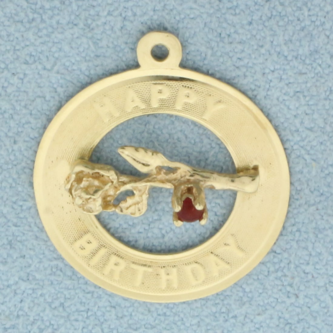 Happy Birthday Ruby Flower Charm in 14k Yellow Gold: In 14k Yellow Gold. Contains one 2mm high quality natural Ruby gemstone with intense color. 7/8 inch long. 3/4 inch wide. 1.3g.