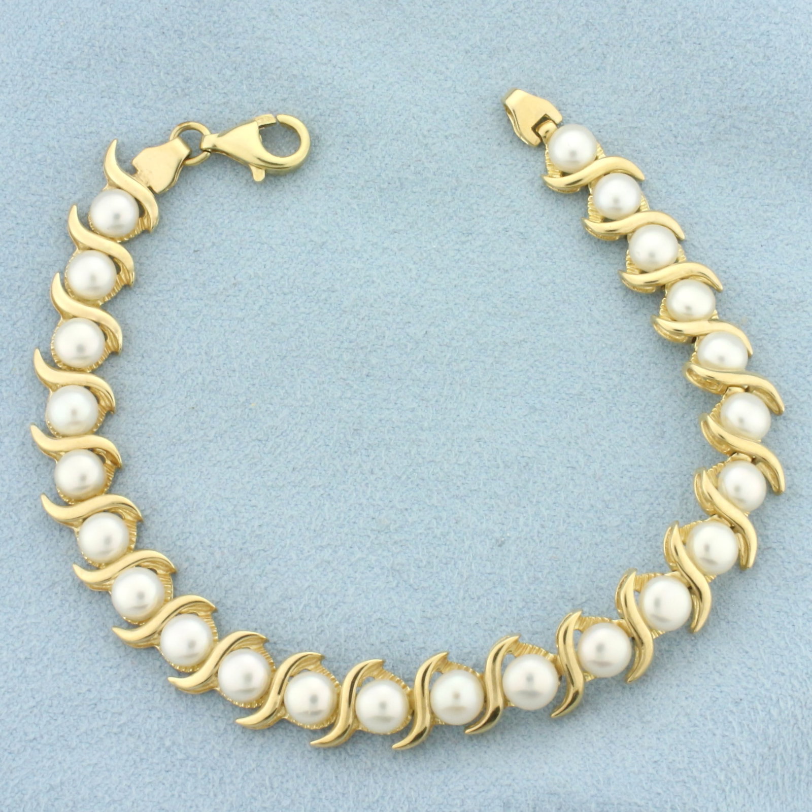 Cultured Akoya Pearl Bracelet in 14k Yellow Gold: In 14k Yellow Gold. Contains twenty-three 5mm high quality Cultured Akoya Pearls with high luster. 7 1/8 inches long. 7.5mm wide. Lobster clasp. 12.3g.