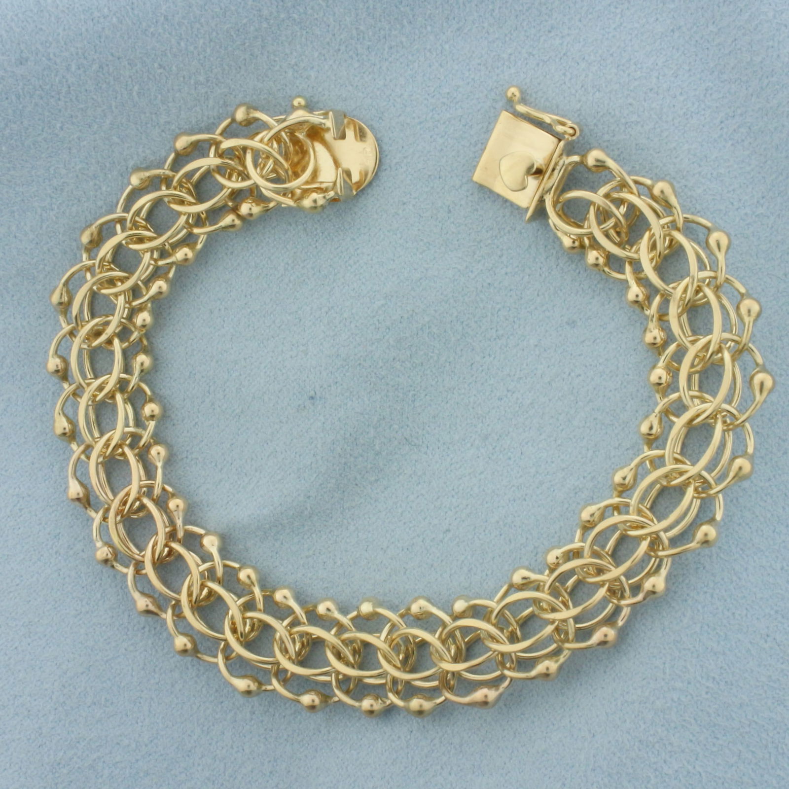 Wide Loop Bead Charm Bracelet in 14k Yellow Gold: In 14k Yellow Gold. 7 1/4 inch long. 1/2 inch wide. Can hang dozens charms on this bracelet. Decorative heart slide clasp with safety latch. 22.6g.