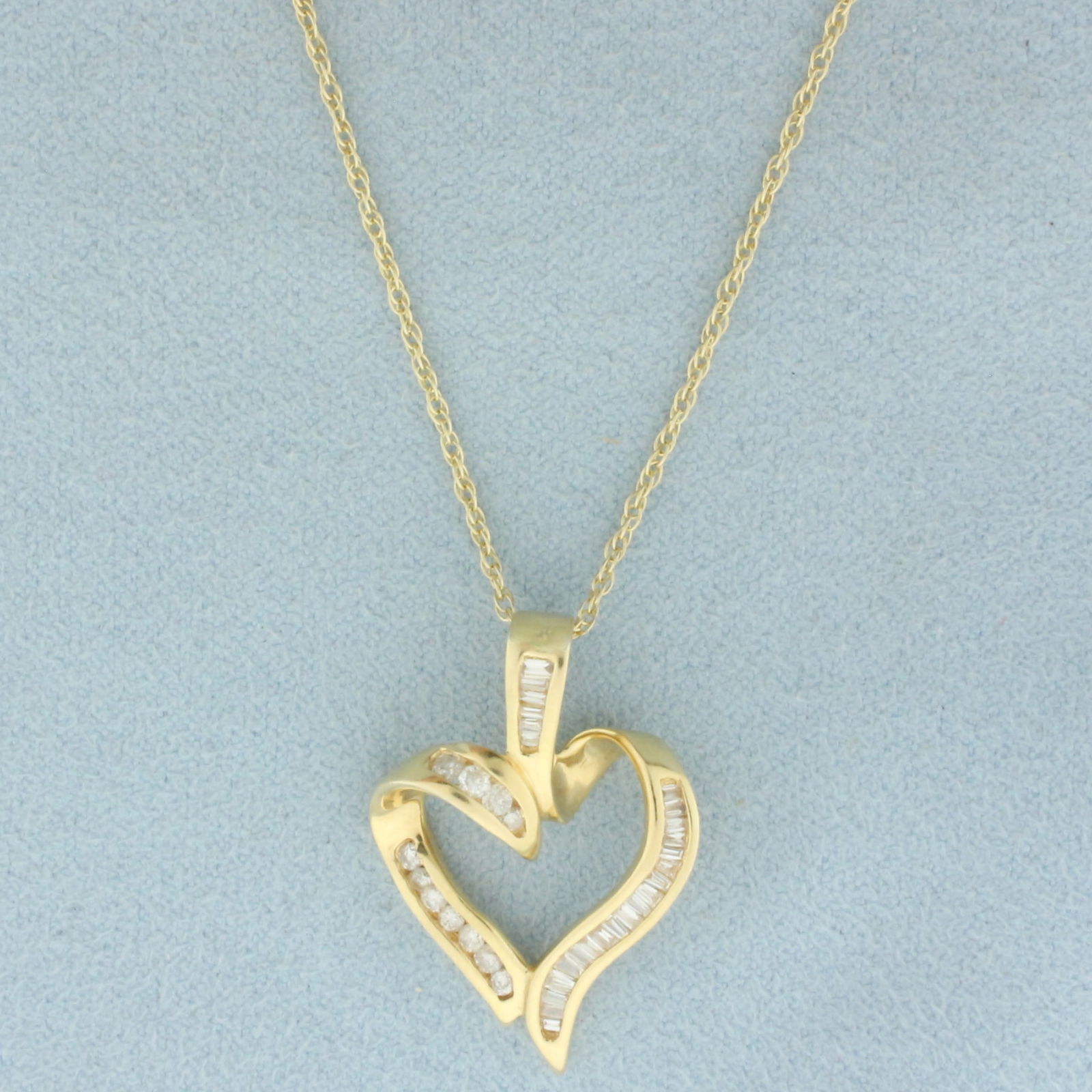 Baguette and Round Diamond Heart Necklace in 14k Yellow Gold: In 14k Yellow Gold. Pendant contains eleven round and twenty-five baguette diamonds, 1/4ct TW, SI clarity/H color. Heart is 1 inch long by 3/4 inch wide. Chain is 19 inches long, 0.7mm wide. 4.5g.