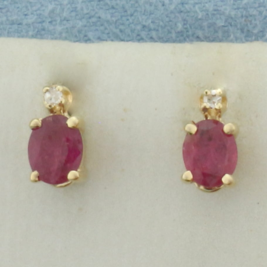 Ruby and Diamond Earrings in 14k Yellow Gold: In 14k Yellow Gold. Contains two 4x5mm high quality oval cut natural Ruby gemstones with vibrant color. Also contains two high quality .01ct diamonds, SI clarity/H color. Friction backs. 1.0g.
