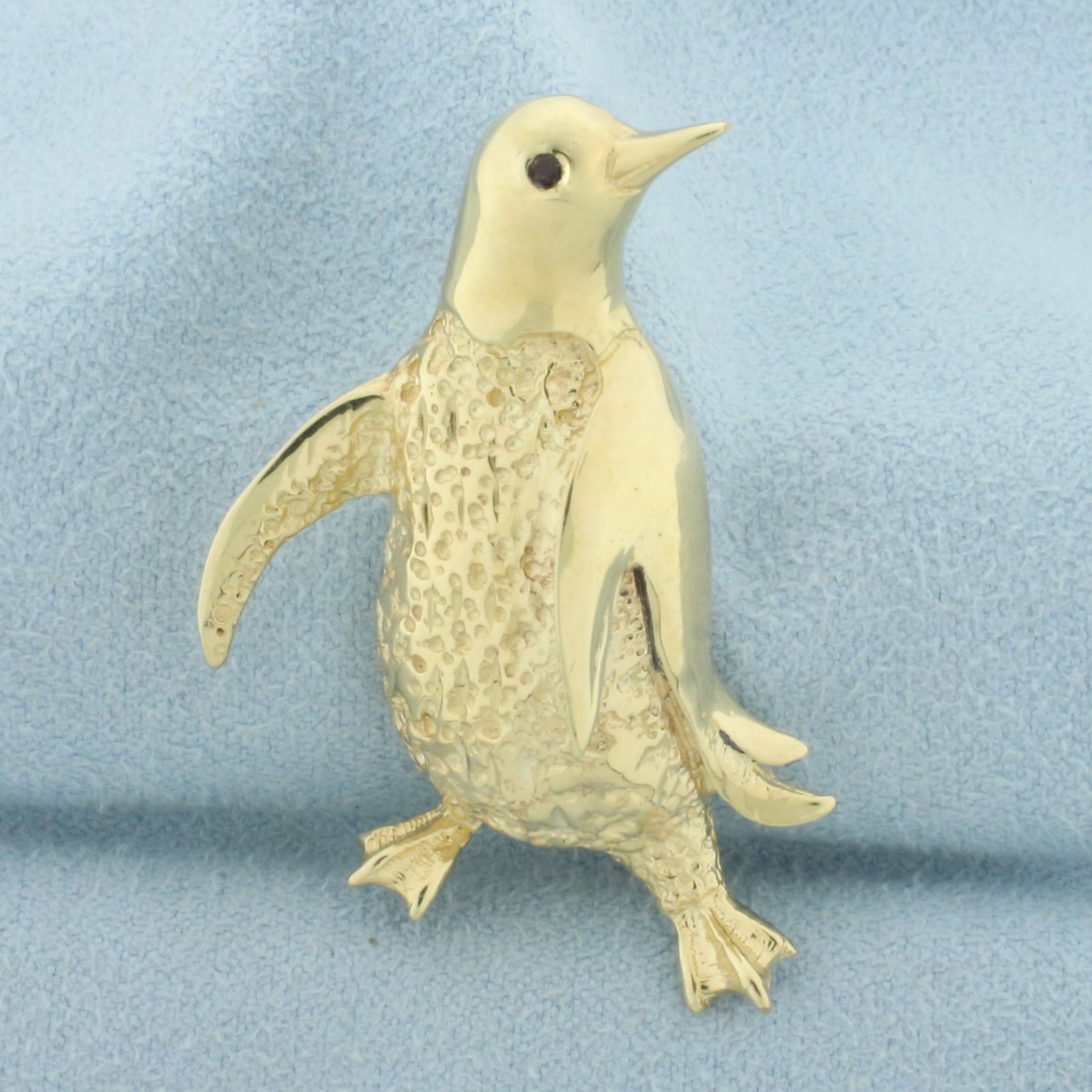Ruby Dancing Penguin Pin in 14k Yellow Gold: In 14k yellow gold. Contains one high quality natural 1.5mm Ruby gemstone as an eye. 1 3/4 inches long, 1 inch wide. 8.2g.