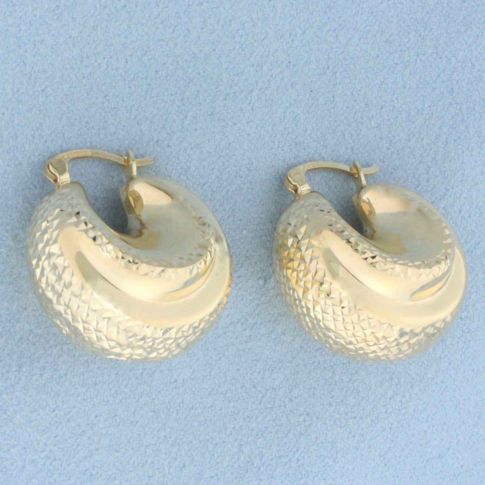 Puffy Textured Hoop Earrings in 14k Yellow Gold: In 14k yellow gold. Diamond cut design for added sparkle. 7/8 inches long and 3/4 inches wide . 16.5mm thick. 4.5g.