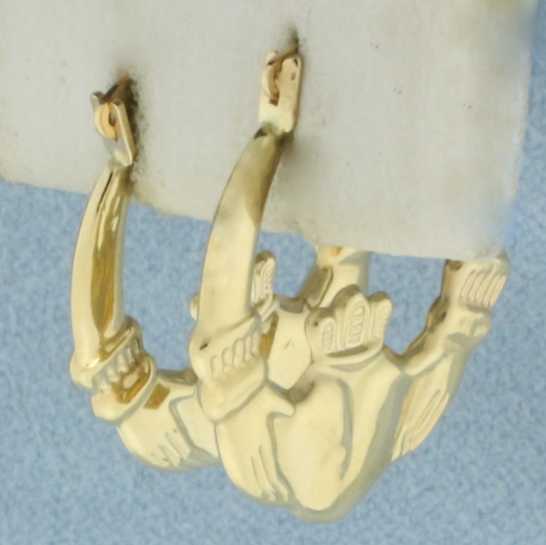 Claddagh Hoop Earrings in 14k Yellow Gold: In 14k Yellow Gold. 7/8 inch long. 3/4 inch wide. Leverbacks. 0.8g.