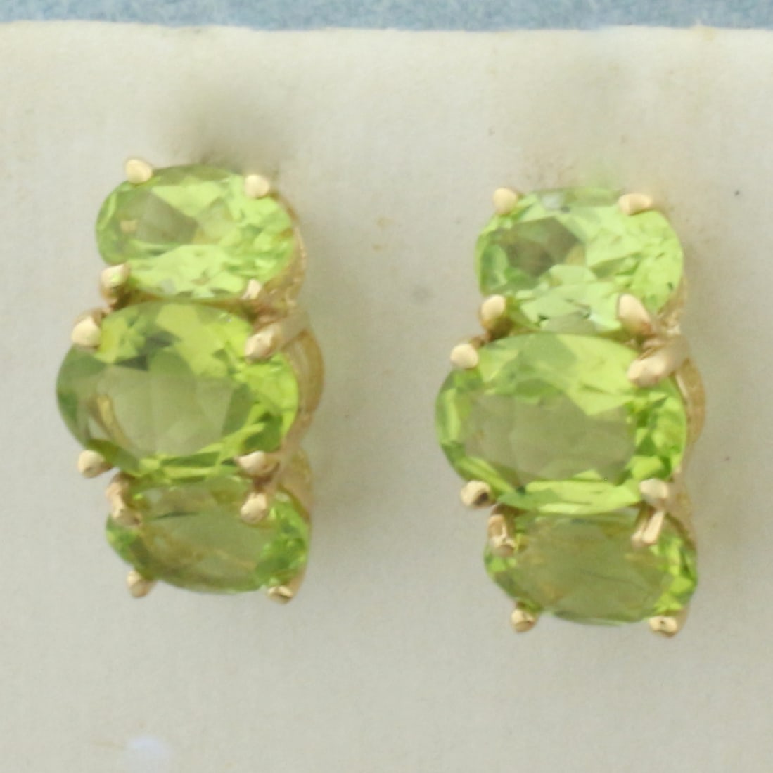 Peridot Half Hoop Earrings in 14k Yellow Gold: In 14k Yellow Gold. Contains two 7x5mm and four 6x4mm high quality natural Peridot gemstones with bright color and excellent clarity. 1/2 inch long. 14 inch wide profile. Friction backs. 2.1g.