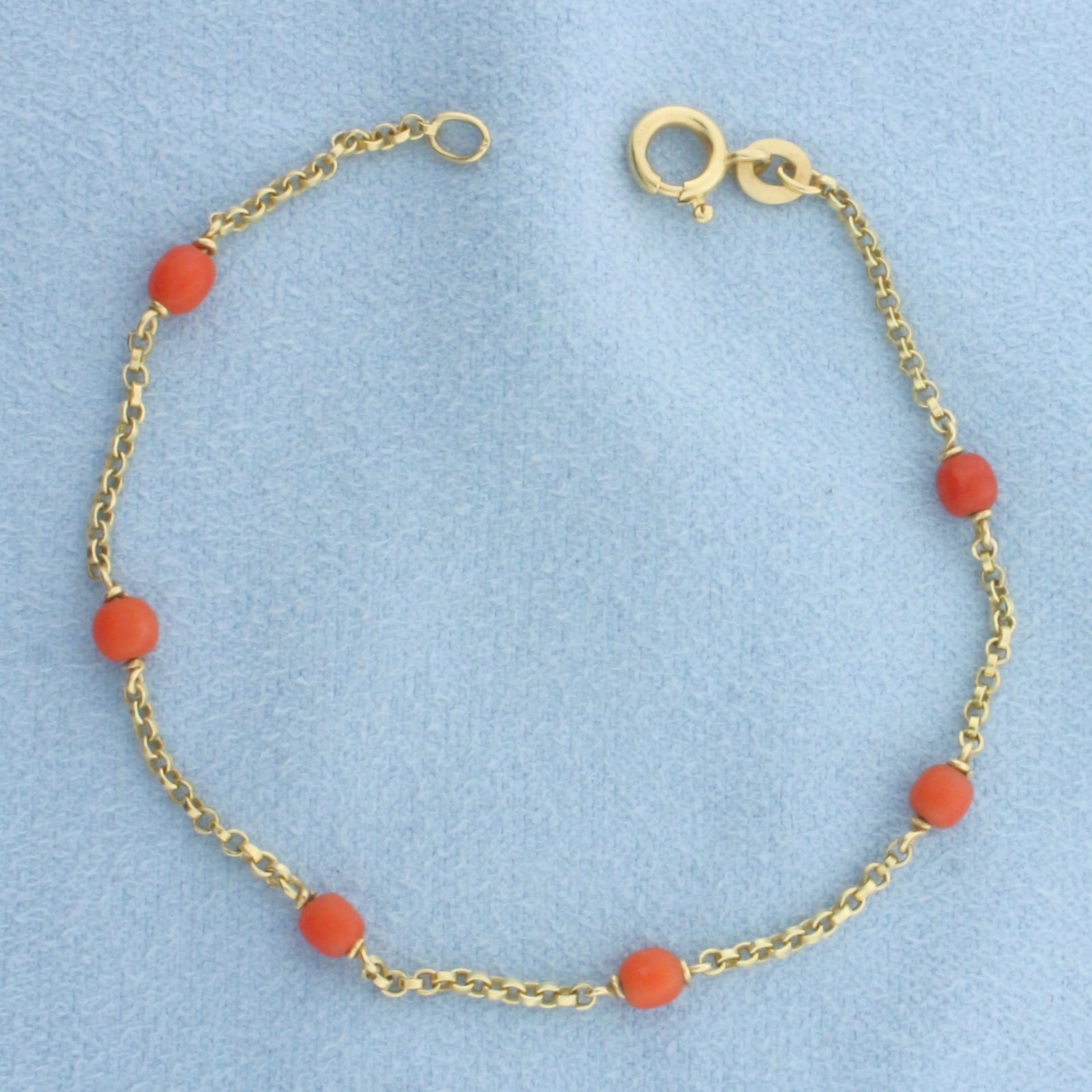 Red Coral Station Bracelet in 18k Yellow Gold: In 18k Yellow Gold. Contains six 3mm high quality Red Coral gemstones with excellent clarity. 6 1/8 inches long. 1.5mm wide cable link chain. Spring clasp. 2.0g.