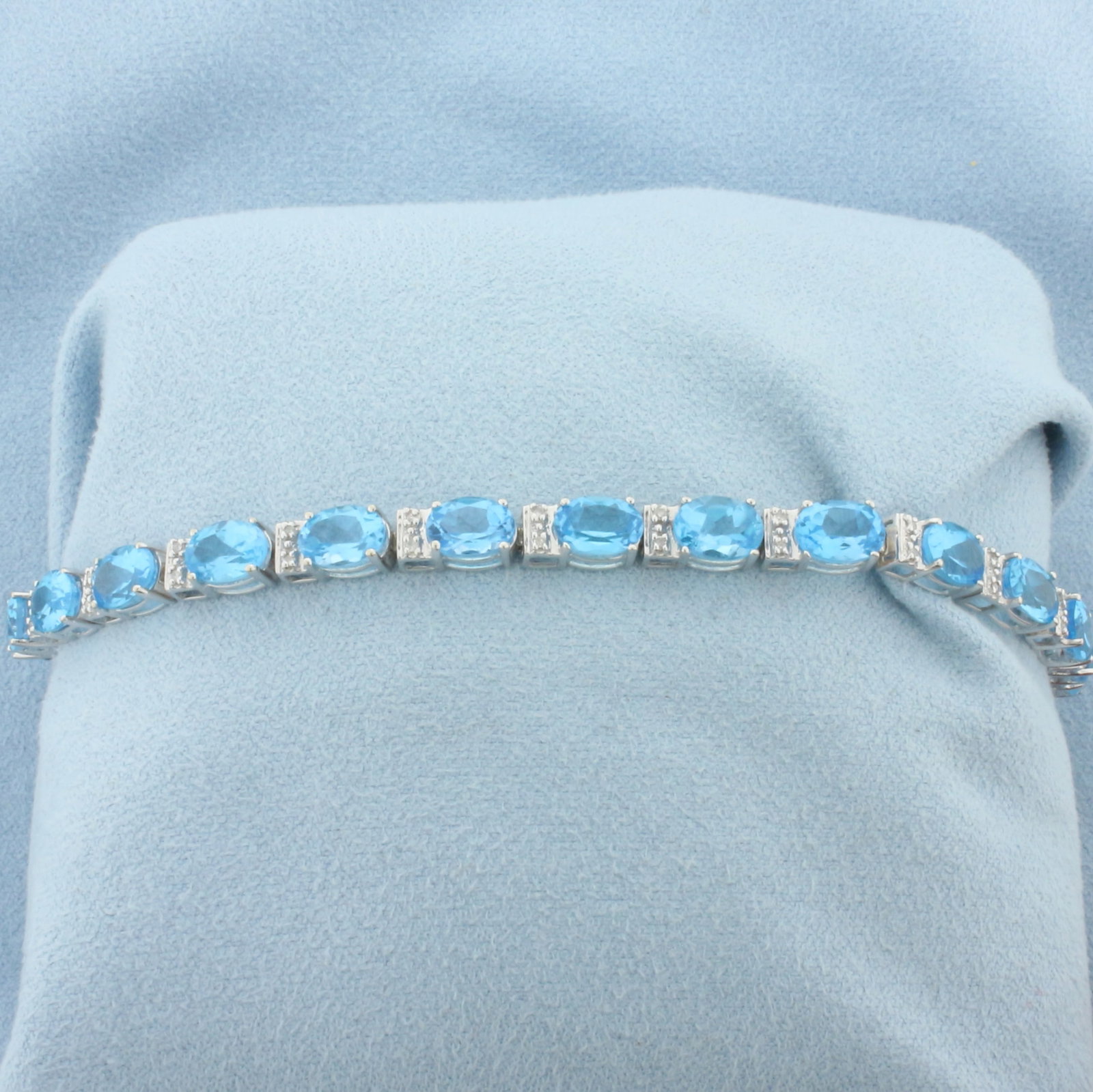 Swiss Blue Topaz and Diamond Tennis Bracelet in 14k White Gold: In 14k White Gold. Contains twenty 5x7mm high quality natural Swiss Blue Topaz gemstones, approximately 20ct TW, with electric blue color and excellent clarity. Also contains forty high quality . 7 3/