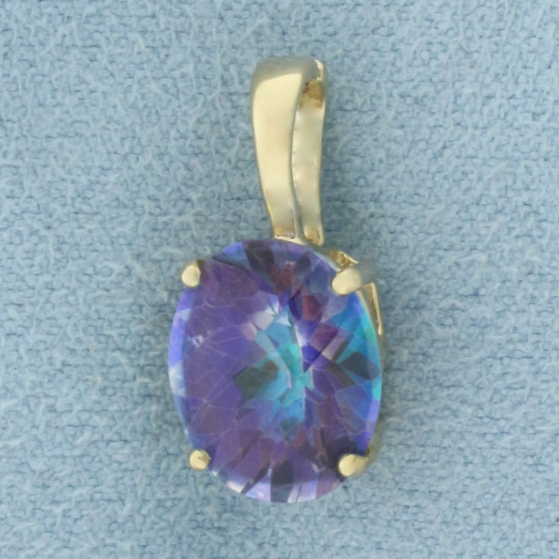 Ocean Blue Mystic Topaz Pendant in 14k Yellow Gold: In 14k Yellow Gold. Contains one 11mm high quality Ocean Blue Mystic Topaz gemstone, approximately 4cts, with vibrant color and excellent clarity. 5/8 inch long. 1/4 inch wide. 1.8g.