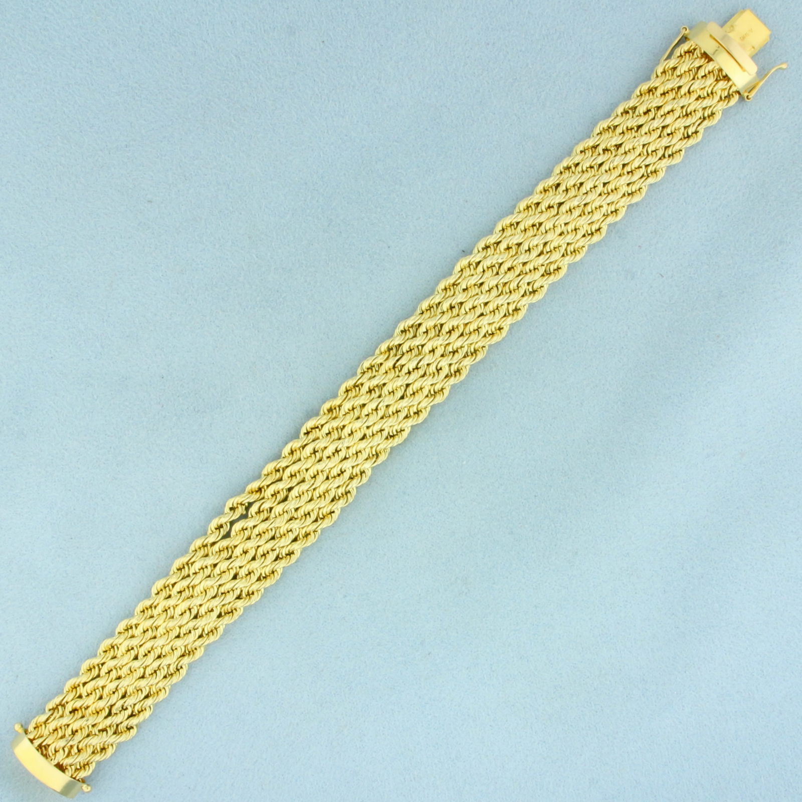 Wide Rope Bracelet in 14k Yellow Gold: In 14k Yellow Gold. 7 1/2 inches long. 5/8 inch wide. Slide clasp with two safety latches. 21.9g.