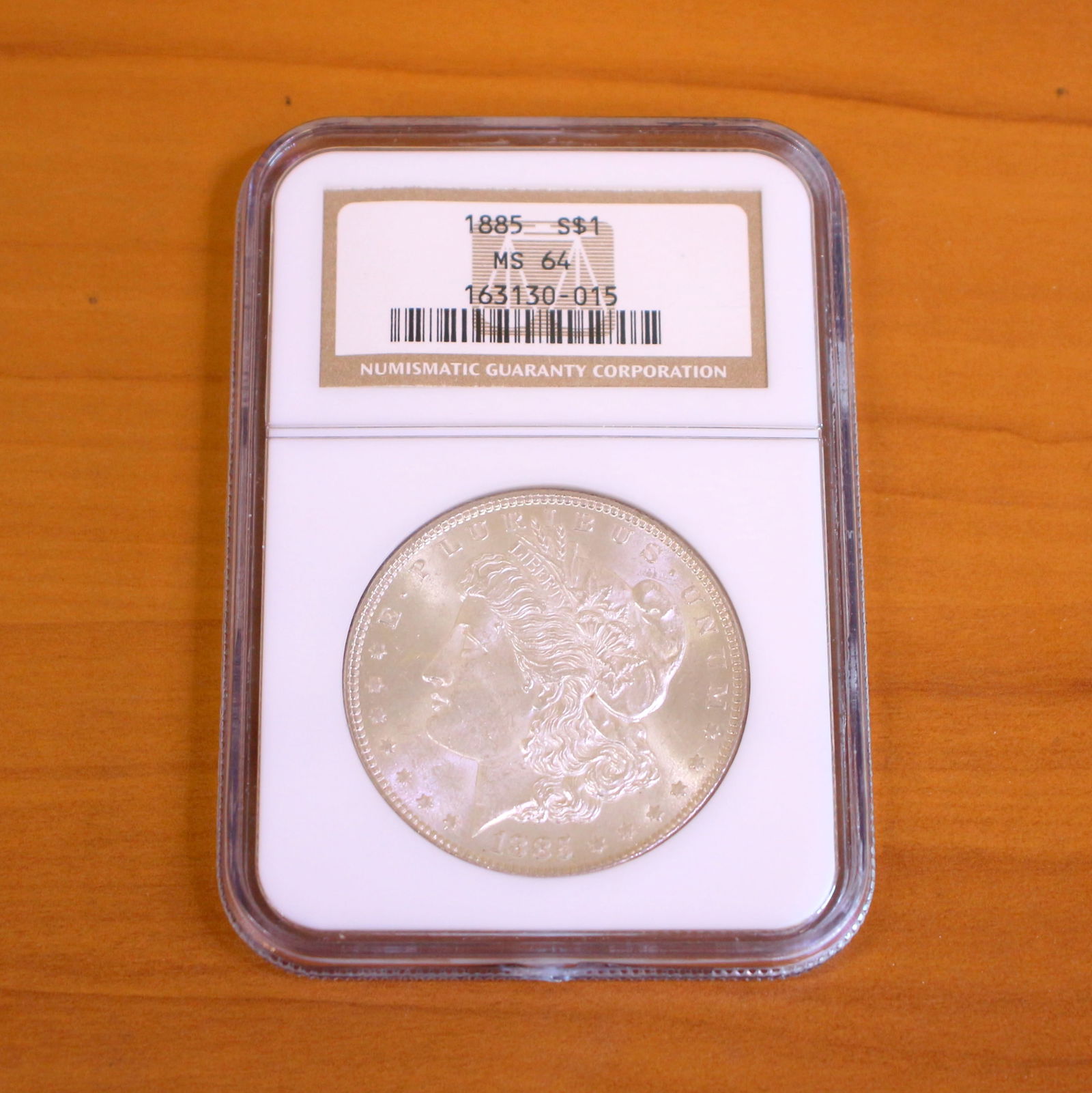 NCG MS64 Morgan Silver Dollar Coin: One coin from 1885, 1886, or 1889. MS64 Grade by Numismatic Guaranty Corporation, NGC.