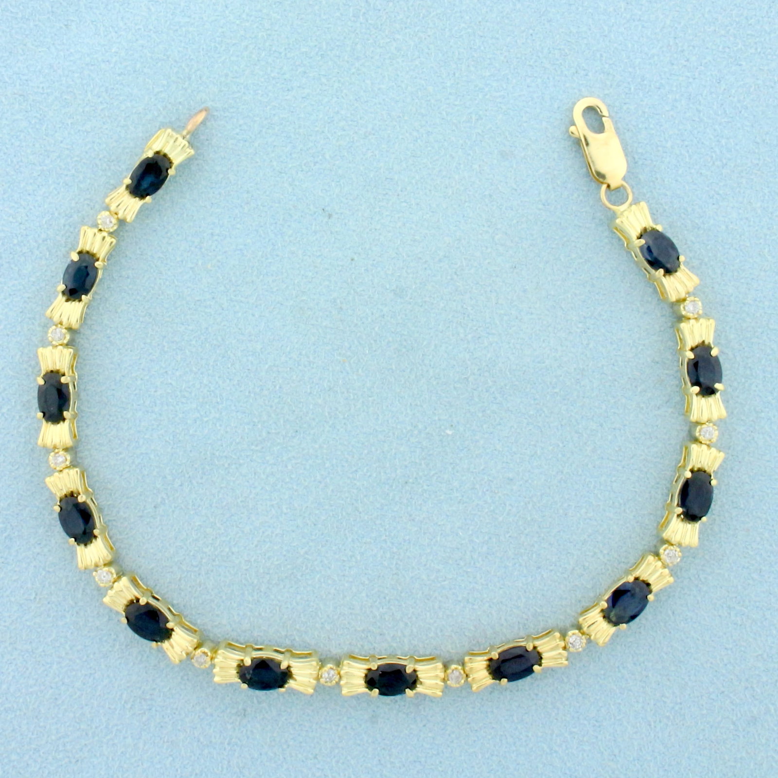 Sapphire and Diamond Line Tennis Bracelet in 14K Yellow Gold: In 14K Yellow Gold. Contains twelve high quality natural 6x4mm oval cut Sapphire gemstones with deep blue color and excellent clarity. Also contains eleven high quality .01ct Diamonds. 6ct TW. 7 3/4 i