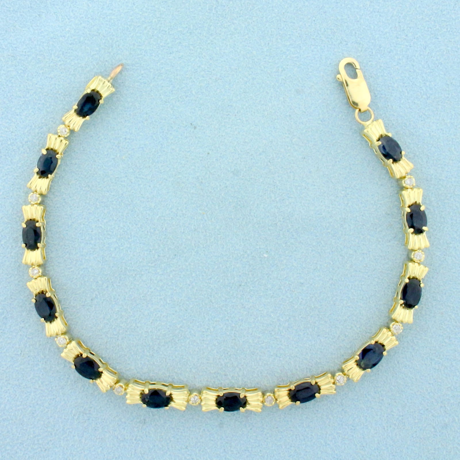 Sapphire and Diamond Line Tennis Bracelet in 14K Yellow Gold: In 14K Yellow Gold. Contains twelve high quality natural 6x4mm oval cut Sapphire gemstones with deep blue color and excellent clarity. Also contains eleven high quality .01ct Diamonds. 6ct TW. 7 3/4 i