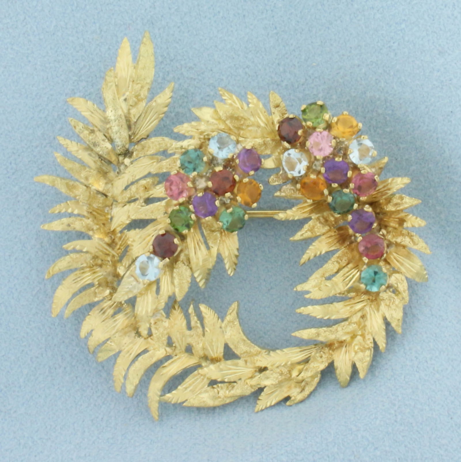 Vintage Rainbow Gemstone Wreath Brooch in 18k Yellow Gold: In 18k yellow gold. Contains 25 high quality natural gemstones, 3.25ct TW, including Morganite, Topaz, Peridot, Amethyst, and Garnet. All with intense color and excellent clarity. 2 inch x 1 7/8 inch.