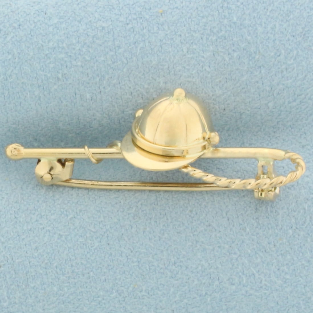Jockey Helmet Riding Crop Racing Horse Brooch in 18k Yellow Gold: In 18k yellow gold. Measures 1 1/2 inch long, 1/2 inch wide. 3.6g.