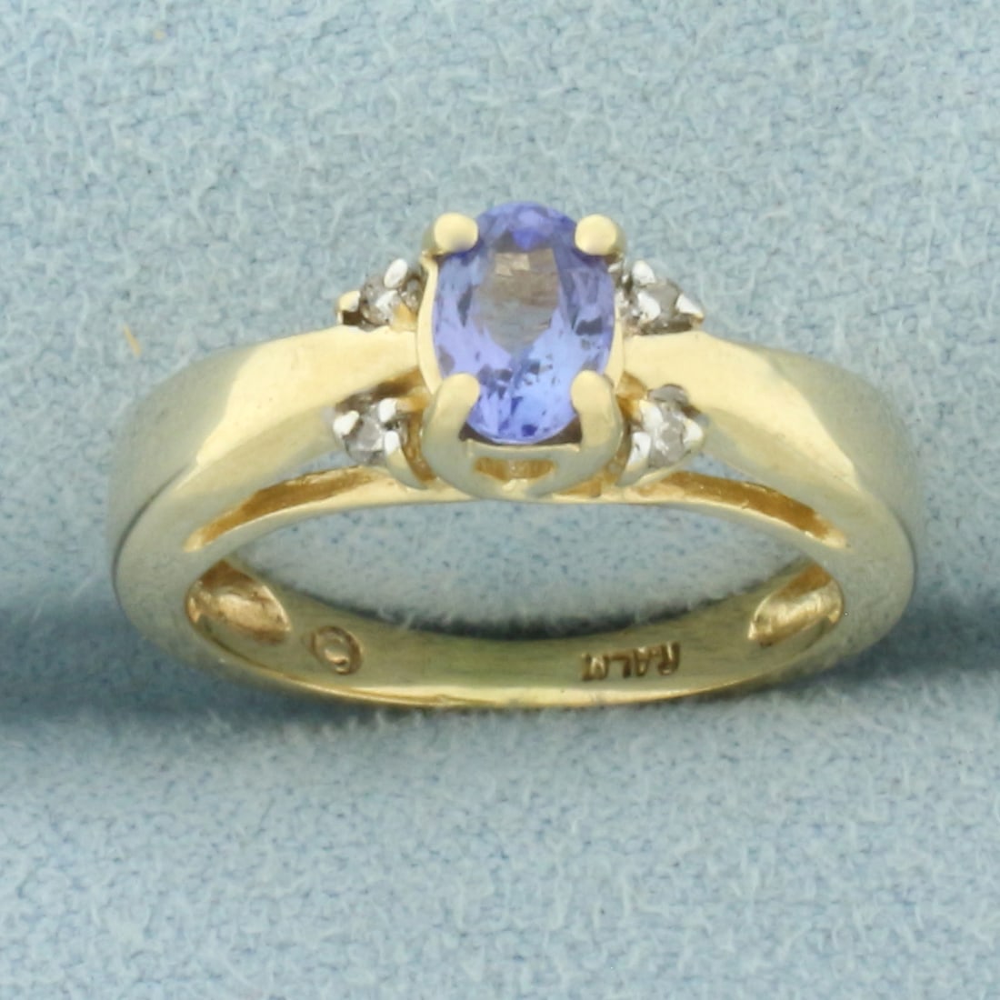 Tanzanite and Diamond Ring in 14k Yellow Gold: In 14k Yellow Gold. Contains one high quality 6mm 1/2ct Natural Tanzanite gemstone with bright color and excellent clarity. Also contains four high quality 1/2pt diamonds. Size 4.75. 3.3g.