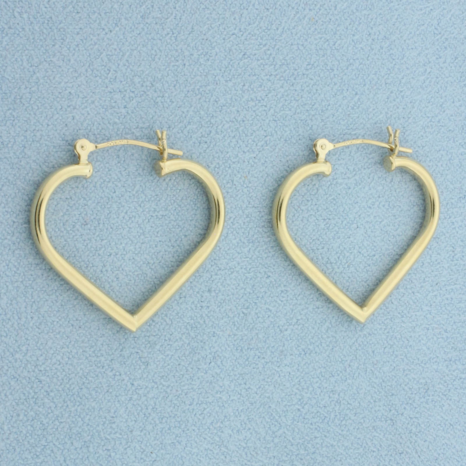 Heart Hoop Earrings in 14k Yellow Gold: In 14k Yellow Gold. 1 inch long. 1 inch wide. 2mm wide tubes. Leverbacks. 1.2g.