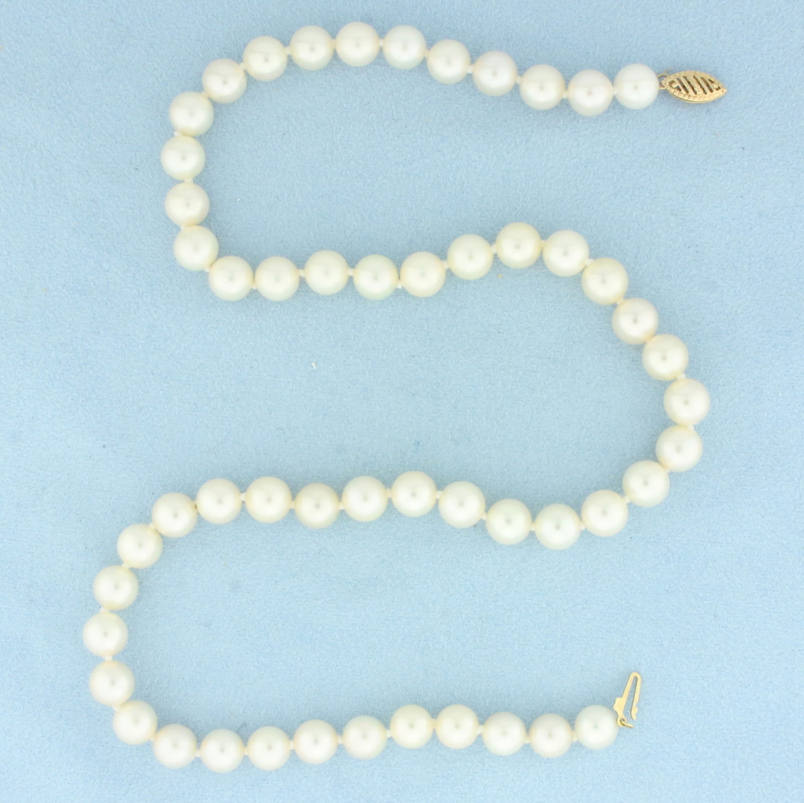 Cultured Akoya Pearl Strand Necklace in 14k Yellow Gold: 14k Yellow Gold clasp. Contains 7.5mm high quality Cultured Akoya Pearls with excellent luster. 18 inches long. Hand knotted. Decorative filigree clasp. 35.0g.