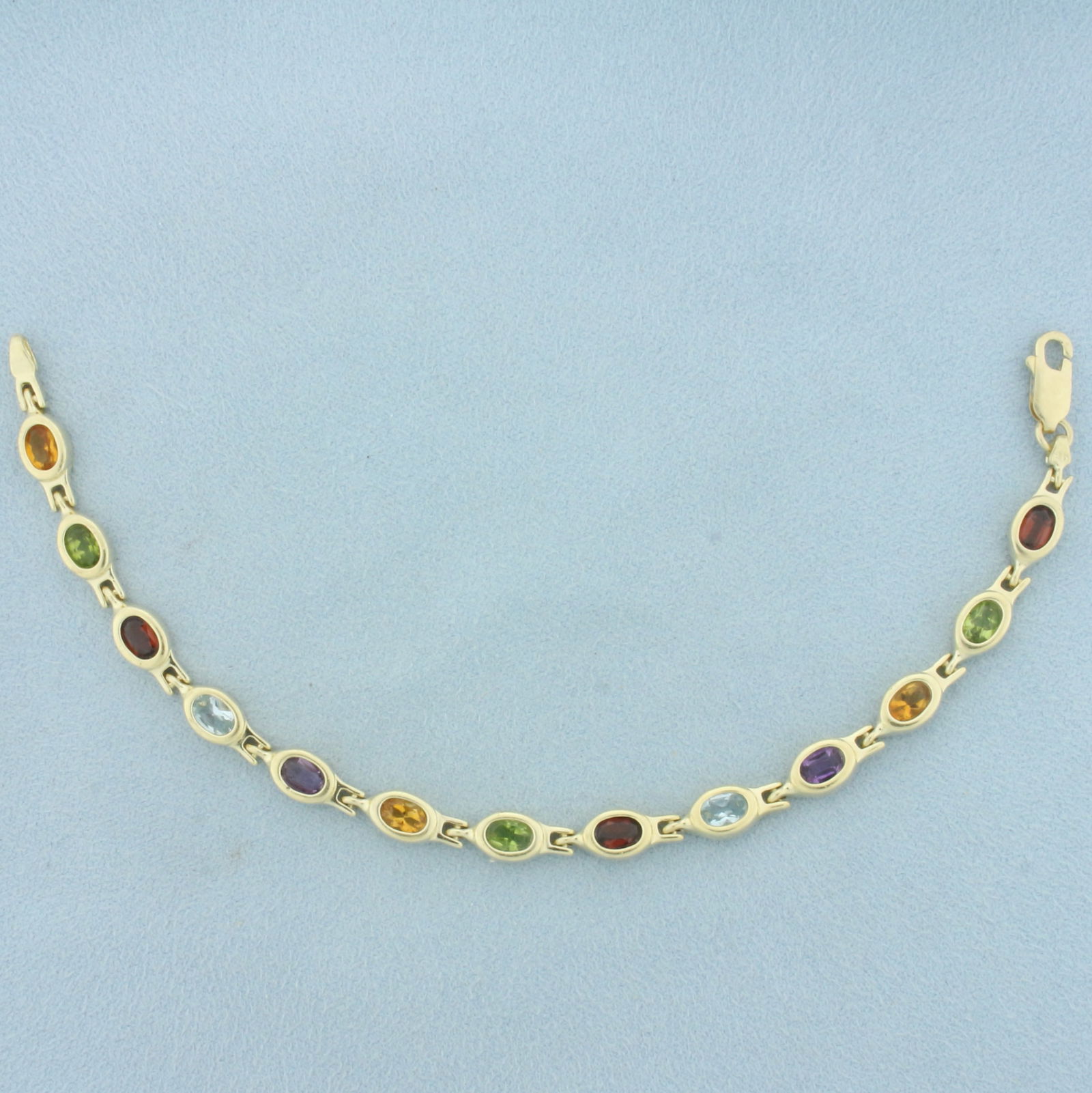Rainbow Gemstone Bracelet In 14k Yellow Gold: In 14k yellow gold. Contains thirteen high quality natural 6mm x 4mm Garnet, Peridot, Citrine, Amethyst, and Blue Topaz gemstones, all with vibrant color and excellent clarity. 7.25 inches long. Lobst
