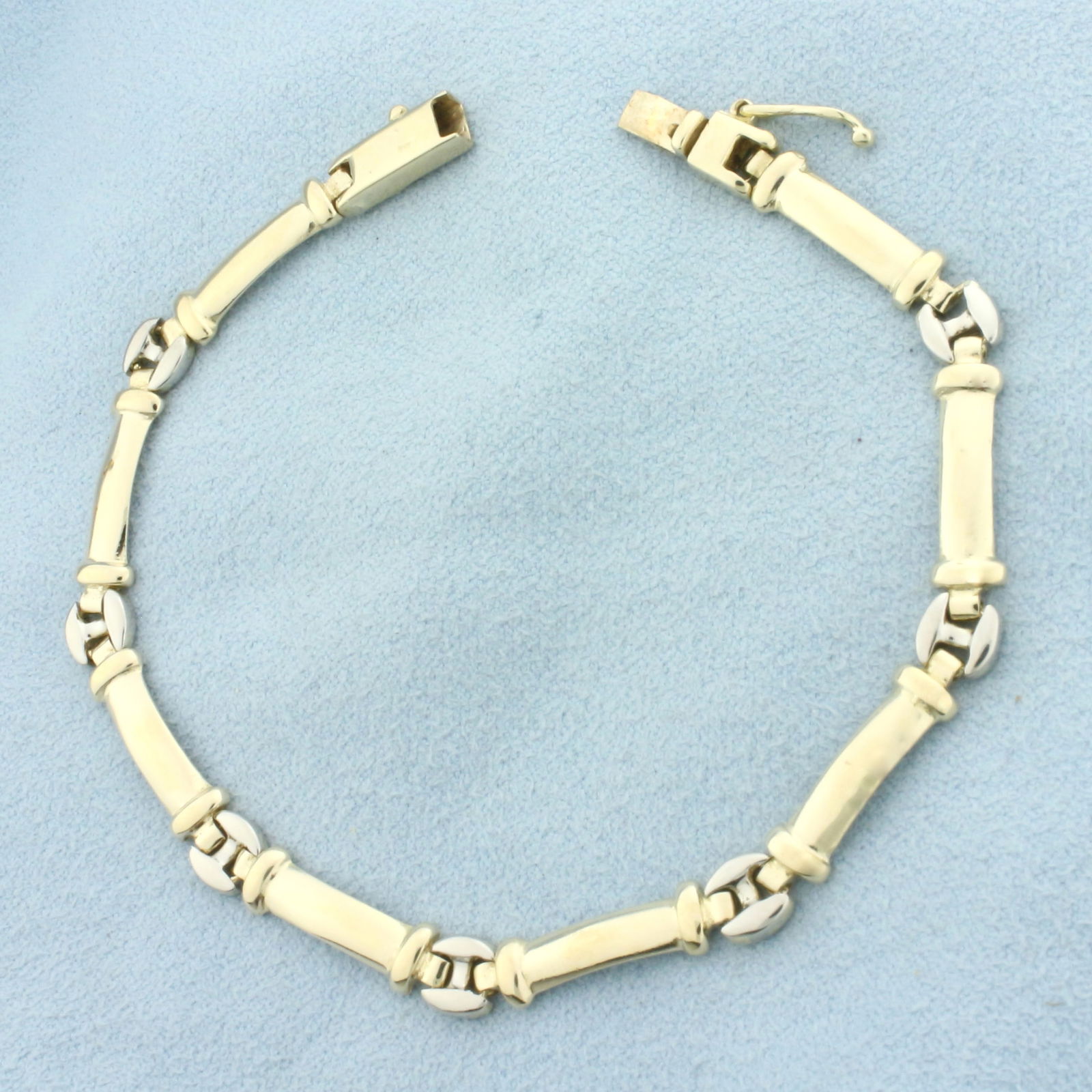 Two Tone Link Bracelet in 14k Yellow and White Gold: In 14k Yellow and White Gold. 7 3/8 inches long. 5.5mm wide. Slide clasp with safety latch. 11.0g.