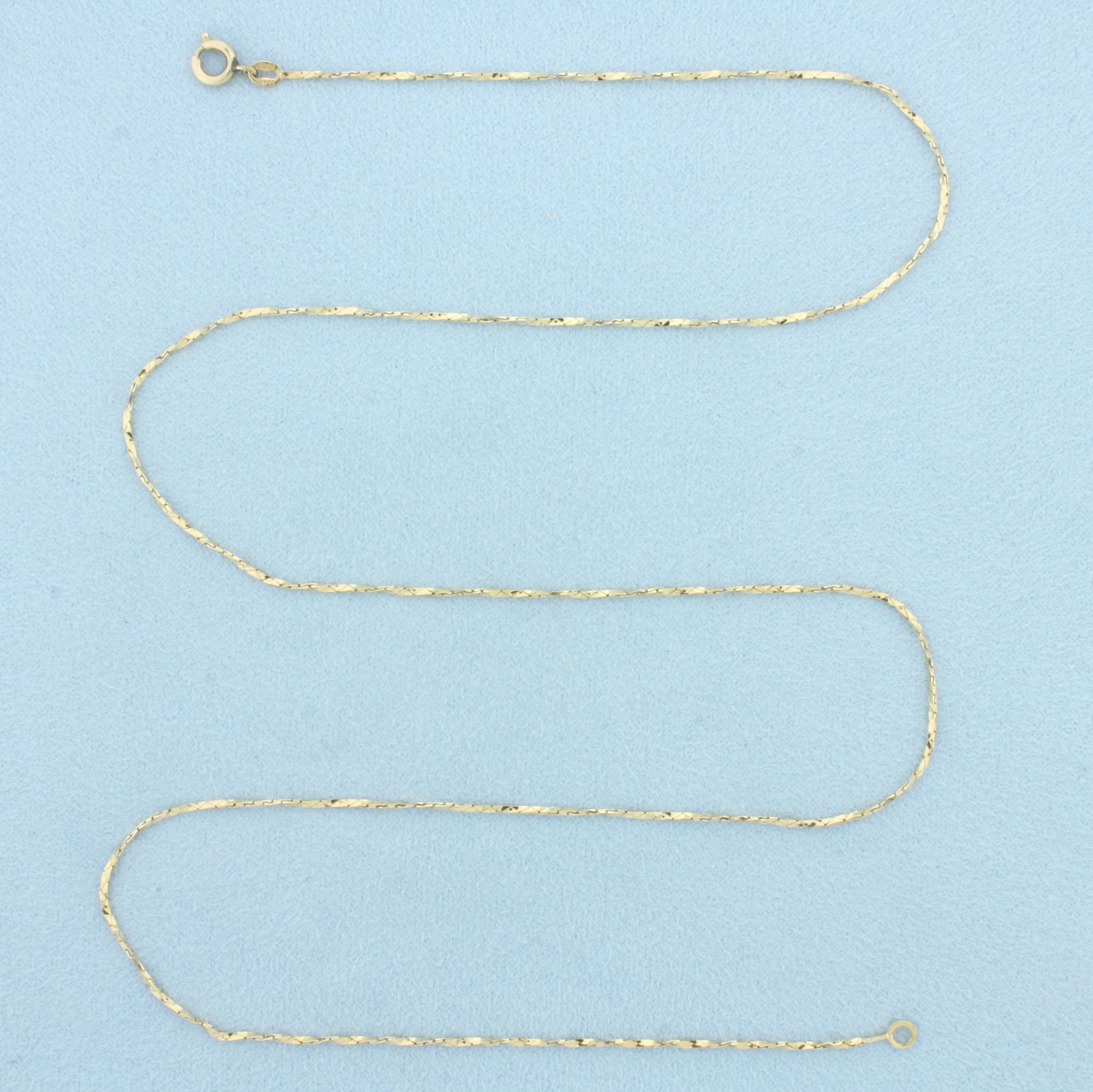 21 Inch Italian Twisting Cobra Link Chain Necklace in 14k Yellow Gold: In 14k Yellow Gold. 21 inches long. 0.9mm wide. Made in Italy. Spring clasp. 2.4g.