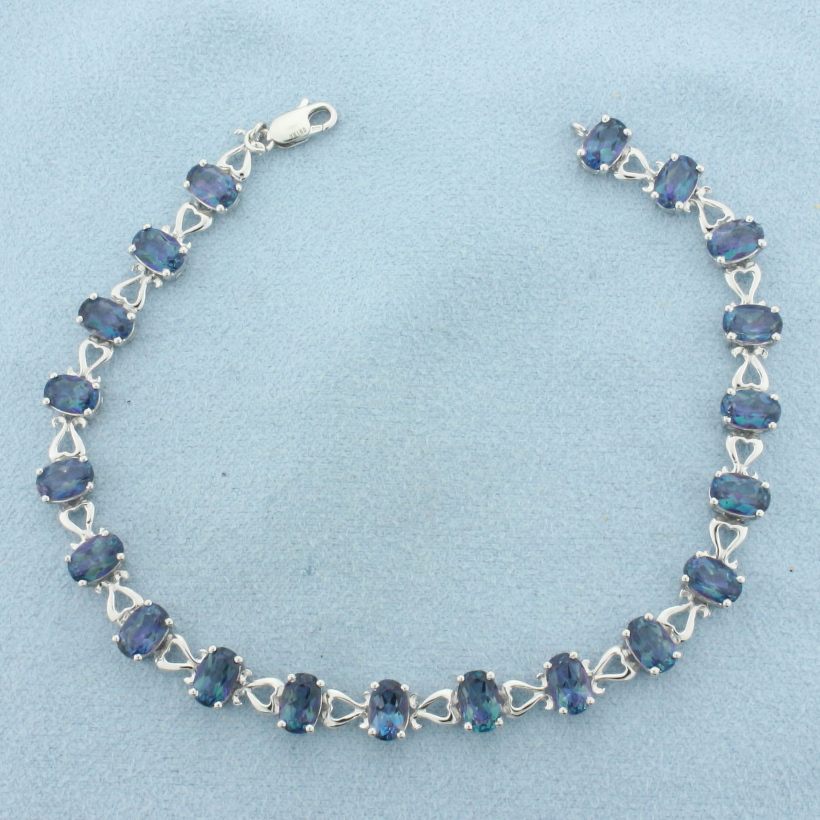 Ocean Mystic Topaz Tennis Bracelet in 10K White Gold: In 10k white gold. Measures 7.5 inches long. Contains 20 high quality 6mm Ocean Mystic Topaz gemstones, approximately 10ct TW, with vibrant color and excellent clarity. Lobster clasp. 6.6g.