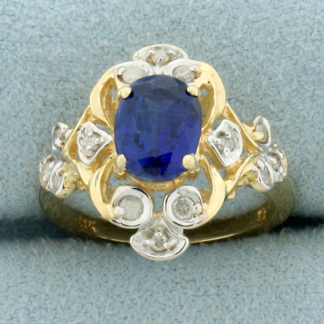 Sapphire and Diamond Scroll Design Ring in 14k Yellow Gold: In 14k yellow gold. Contains one high quality 8x6mm oval cut sapphire, 1.5ct, with intense color and excellent clarity. Also contains 14 high quality .01ct diamonds, I color/I clarity. Size: 5.25. 4.6