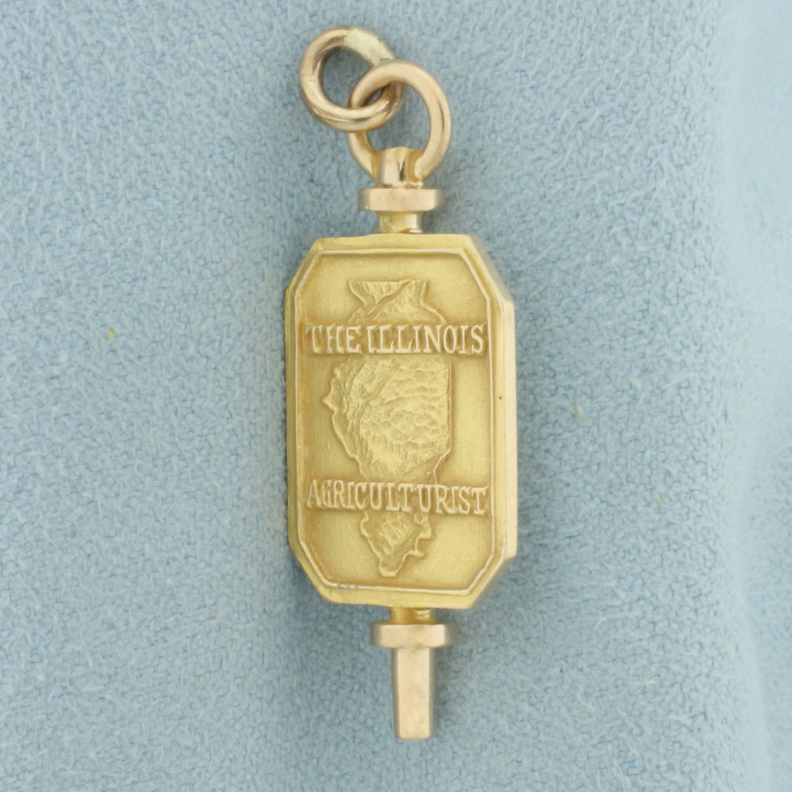 The Illinois Agriculturist Pendant or Charm in 10k Yellow Gold: In 10k yellow gold. 1 3/8 inches long and 5/8 inches wide. 3.7g.