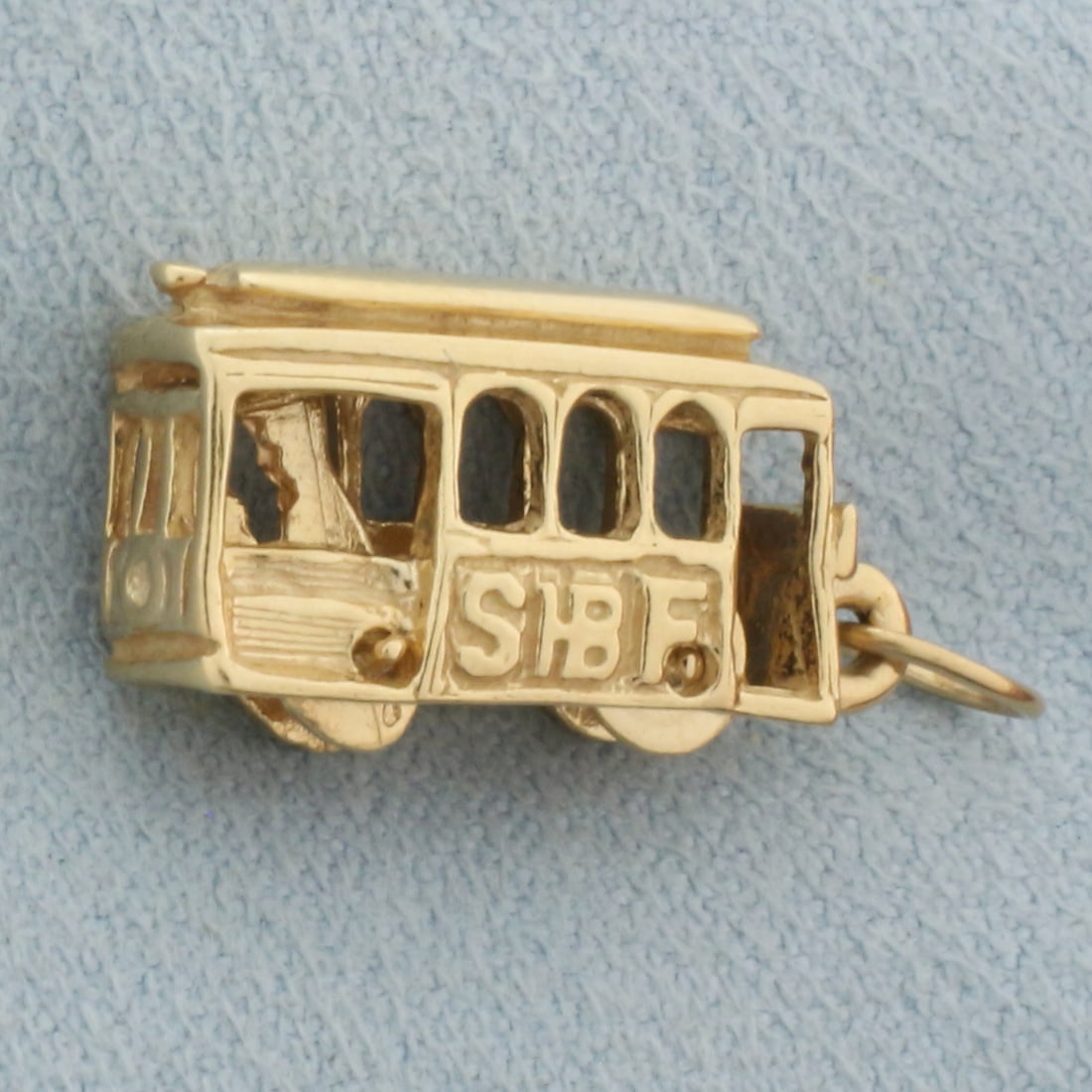 Mechanical Cable Car Pendant in 14k Yellow Gold: In 14k yellow gold. Wheels rotate, engineer rocks back and forth. 7/8 inches long and 1/2 inch wide. 3.6g.