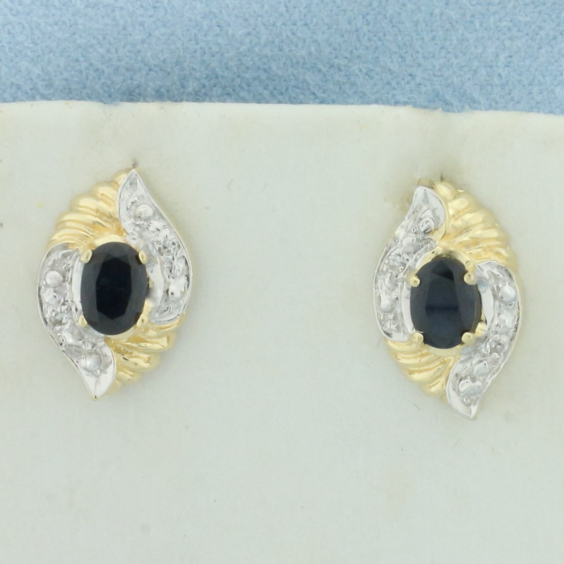 Sapphire and Diamond Button Earrings in 14k Yellow Gold: In 14k yellow gold. Contains two high quality natural 4mm by 6mm oval Sapphire gemstones, 1ct TW, with deep color and excellent clarity. Also contains four high quality 1/2pt diamonds. 5/8 inches long