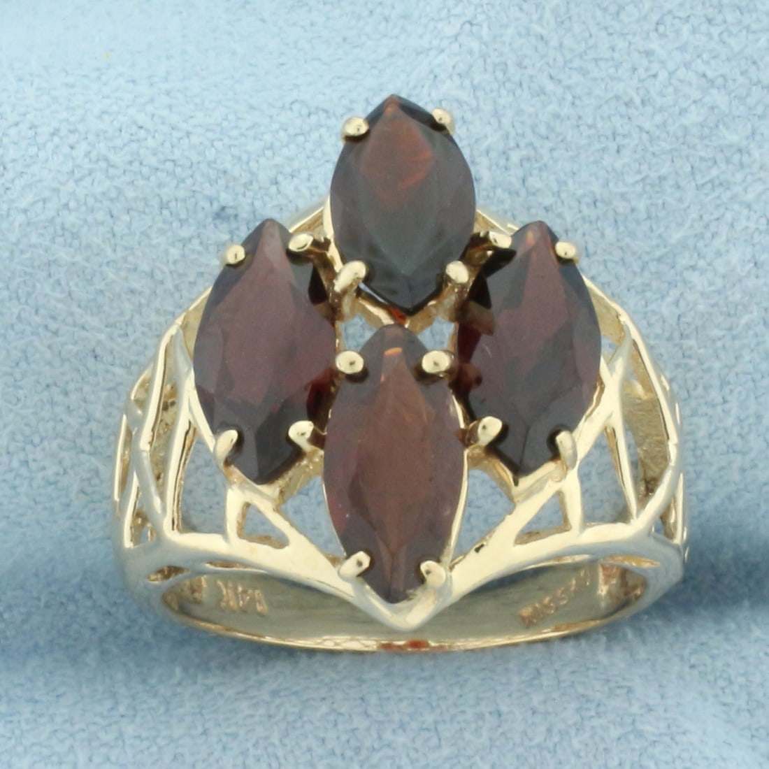 Marquise Garnet Ring in 14k Yellow Gold: In 14k yellow gold. Contains four high quality 10mm by 5mm marquise cut Garnet gemstones, approximately 1ct each, with vibrant color and excellent clarity. 19mm wide at center. Size :7.25. 4.9g.