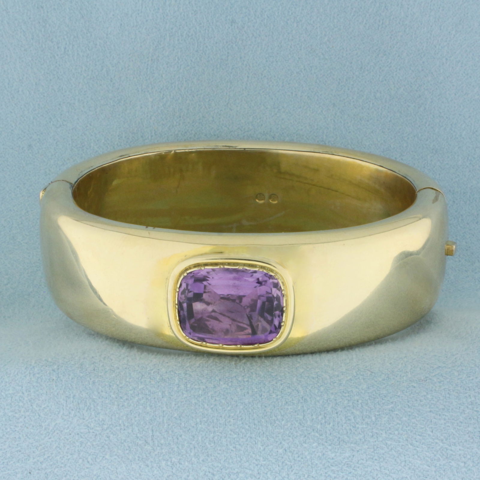 Vintage Amethyst Wide Hinged Bangle Bracelet in 14k Yellow Gold: In 14k Yellow Gold . Contains one natural high quality 16mmx13mm Amethyst gemstone with intense color and excellent clarity. 20mm wide. Interior dimensions: 2 1/4 inch by 1 3/4 inch. Minor indentation