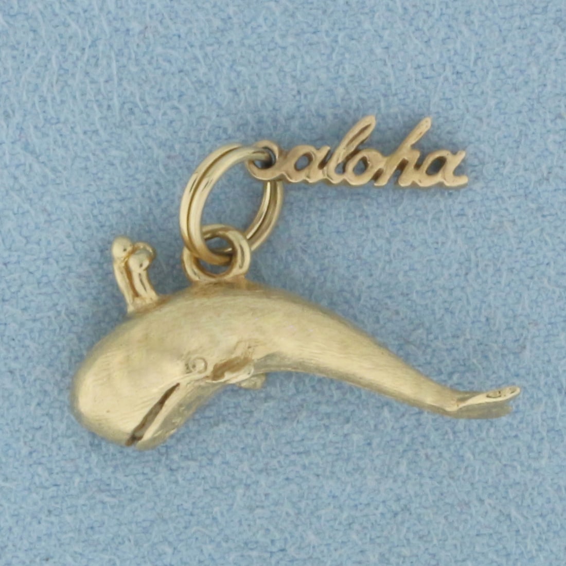 Aloha Humpback Whale Charm in 14k Yellow Gold: In 14k Yellow Gold. 5/8 inch long. 7/8 inch wide. 3D. Spring bale for ease of attachment to charm bracelet or necklace. 4.4g.