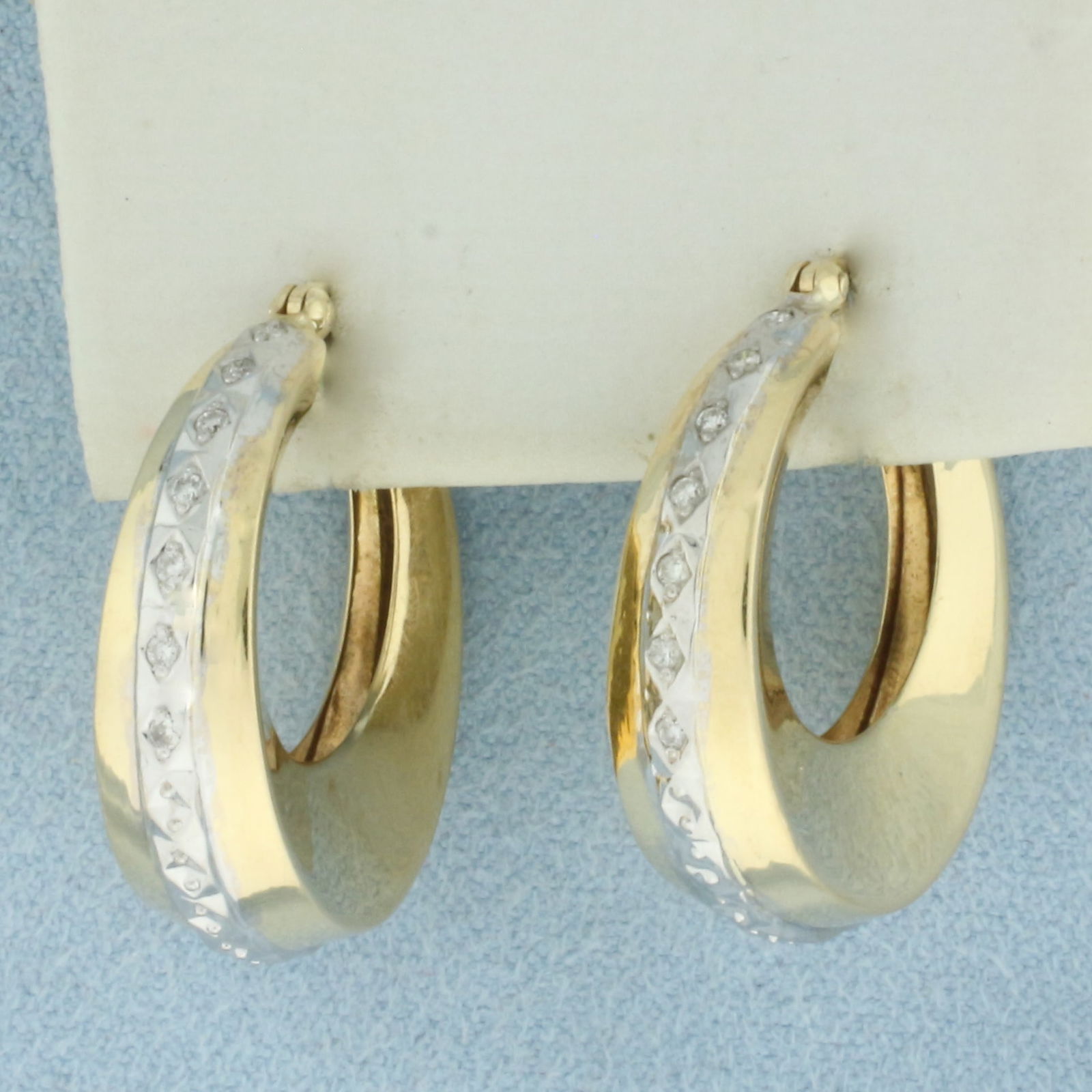 Diamond Hoop Earrings in 14k Yellow and White Gold: In 14k Yellow and White Gold. Contains fourteen high quality 1/2pt diamonds. 1 inch long. 1 inch wide. 7mm wide at widest point.5.2g.