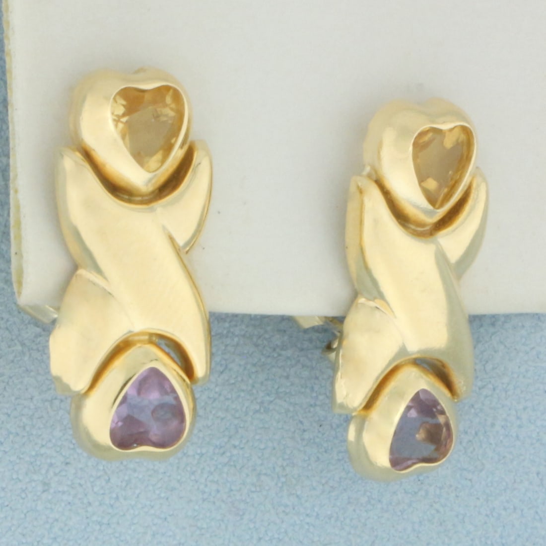 Amethyst and Citrine Heart Drop Earrings in 14k Yellow Gold: In 14k Yellow Gold. Contains two 6mm heart Amethyst and Citrine gemstones with vibrant color and excellent clarity. 1 inch long. 1/2 inch wide. For Pierced Ears. Omega backs. 6.9g.