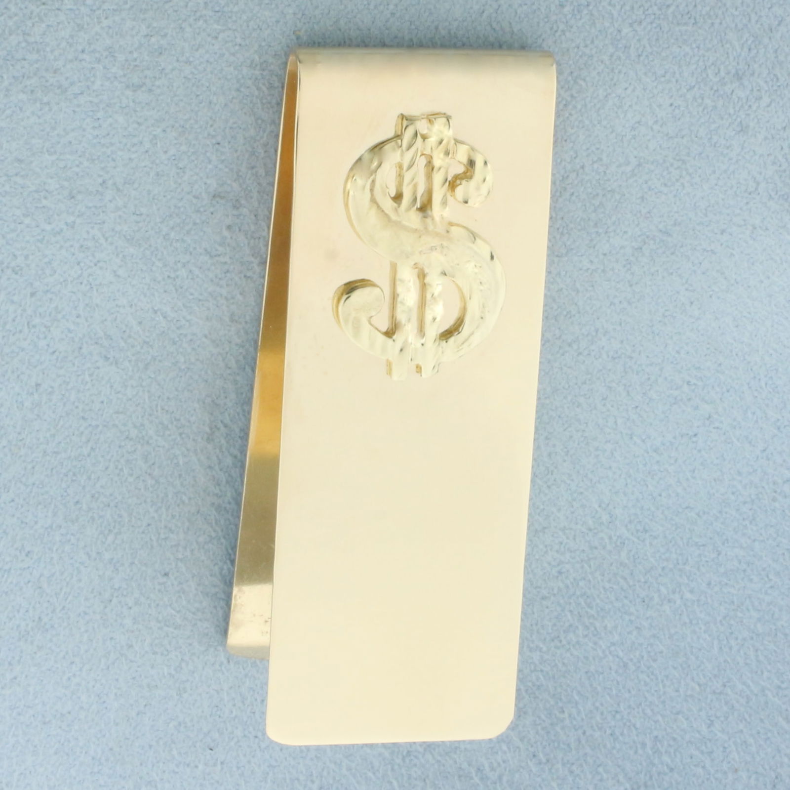 Dollar Sign $ Money Clip in 14k Yellow Gold: In 14k Yellow Gold. 2 inches long. 3/4 inch wide. 15.7g.