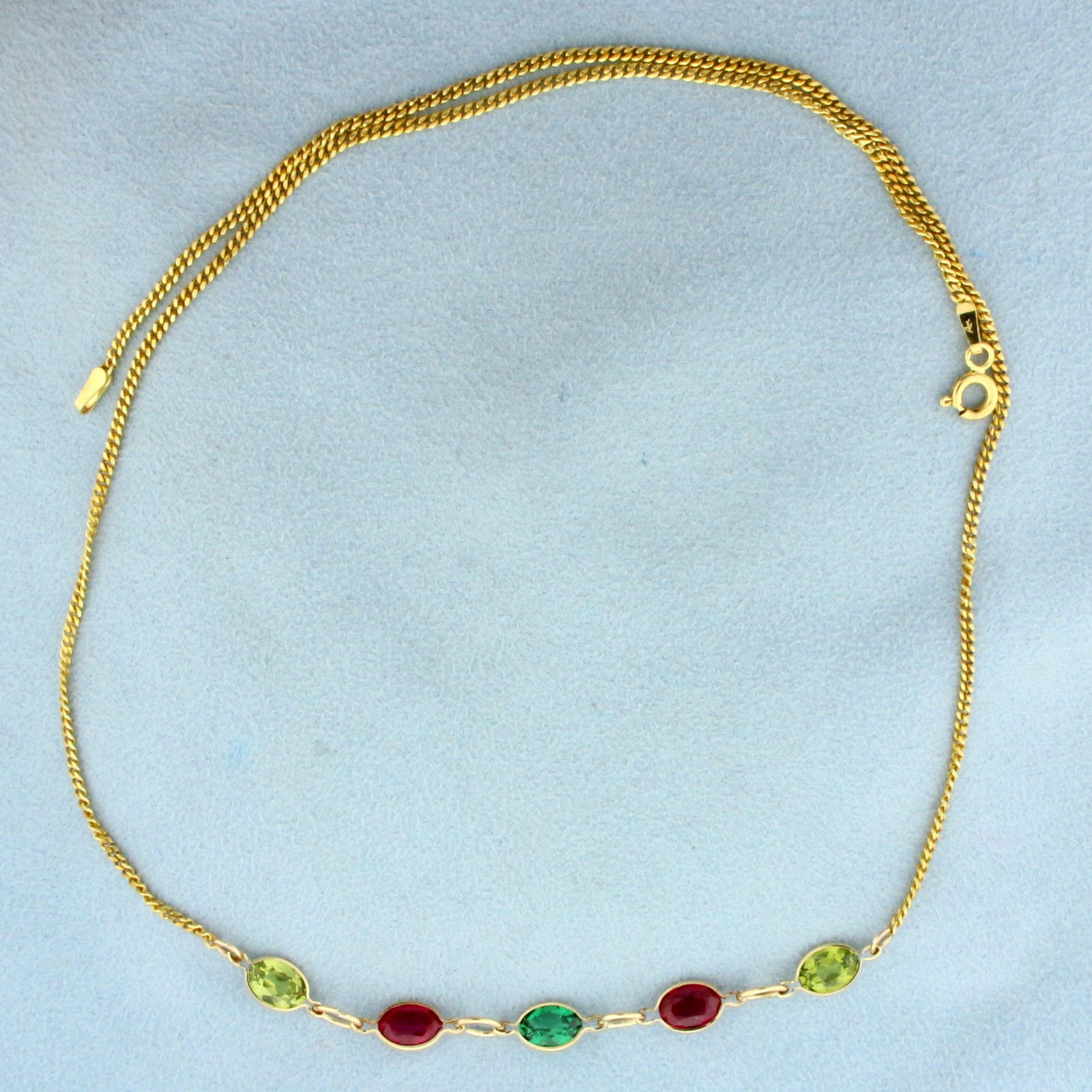Emerald, Ruby, and Peridot Necklace in 14K Yellow Gold: In 14K Yellow Gold. Contains one Lab Emerald, Two Lab Ruby and two Peridot high quality 7x5mm oval cut gemstones with vibrant color and excellent clarity. 5ct TW. 18 inches long, with spring clasp. 5.
