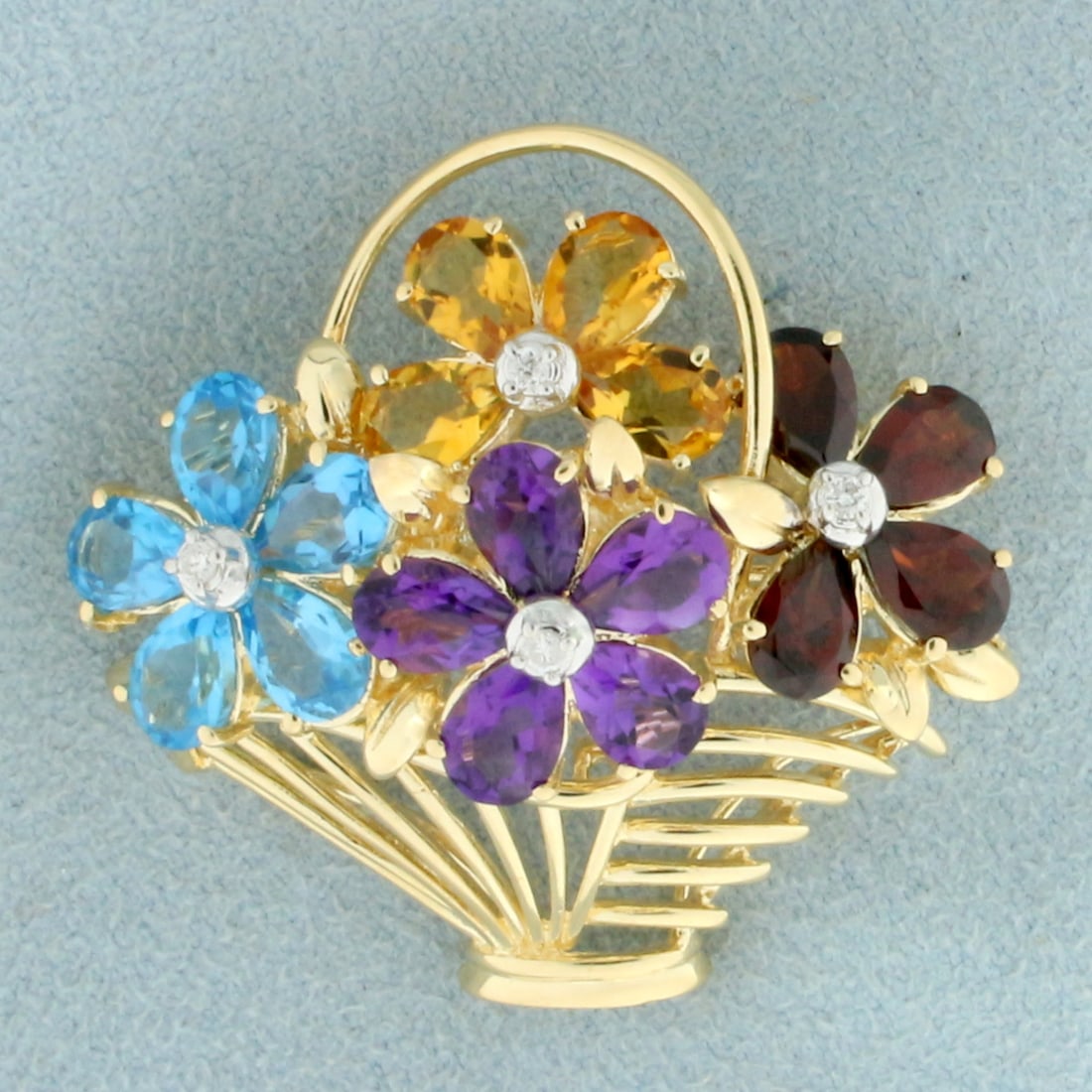 Rainbow Gemstone and Diamond Flower Basket Brooch in 14K Yellow Gold: In 14K Yellow Gold. Contains five high quality natural 4x6mm pear cut Amethyst and Blue Topaz gemstones and four Citrine and Garnet gemstones all with vibrant color and excellent clarity. Also contain